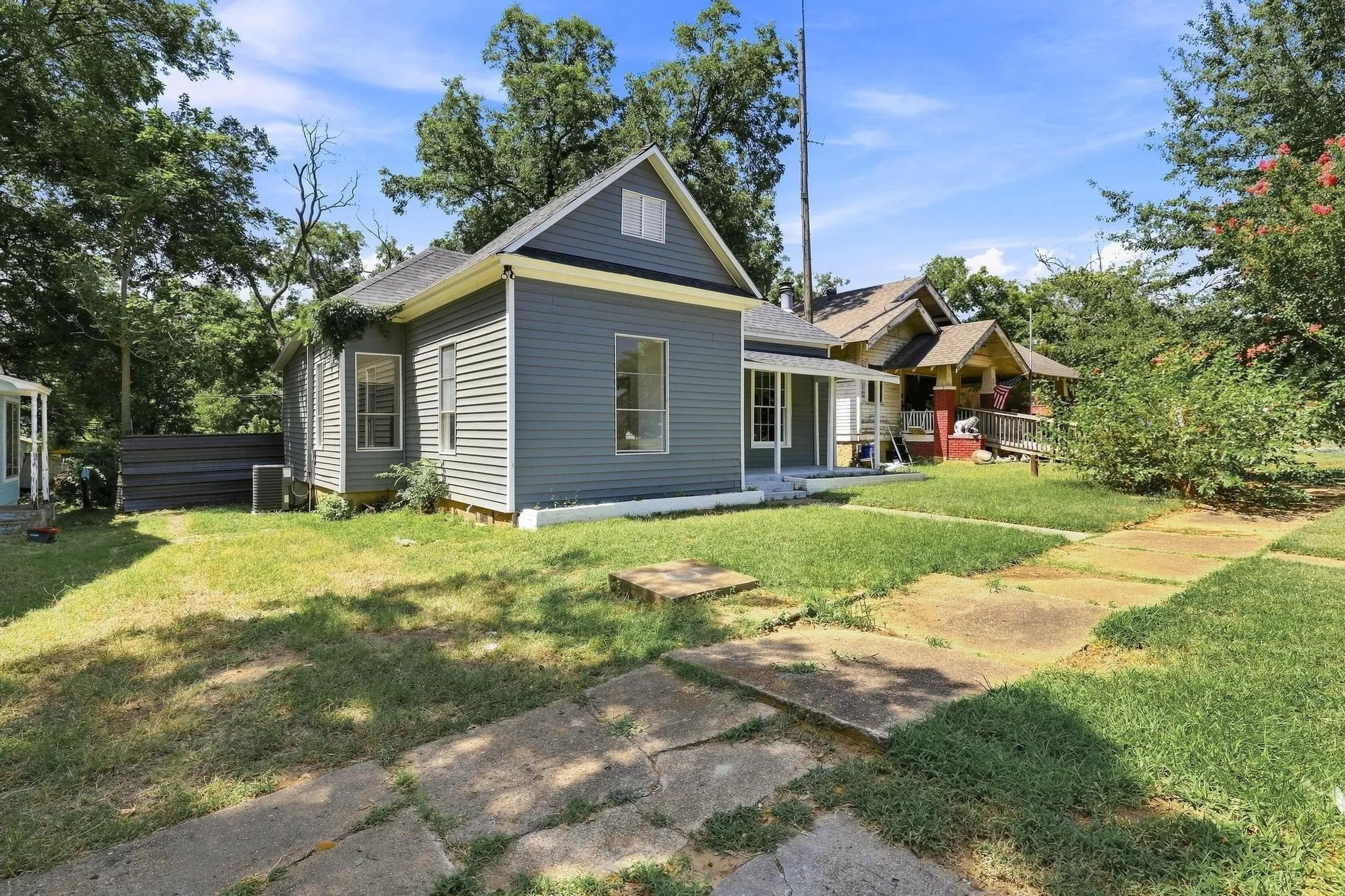 Charming exterior featuring gray siding, white trim, and a covered front porch with white columns