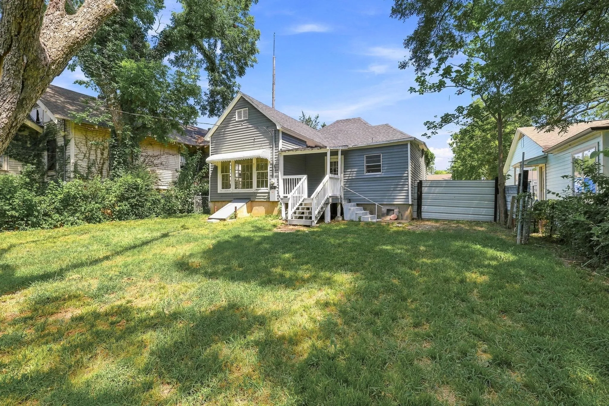 Spacious backyard featuring a sloped lawn and mature trees