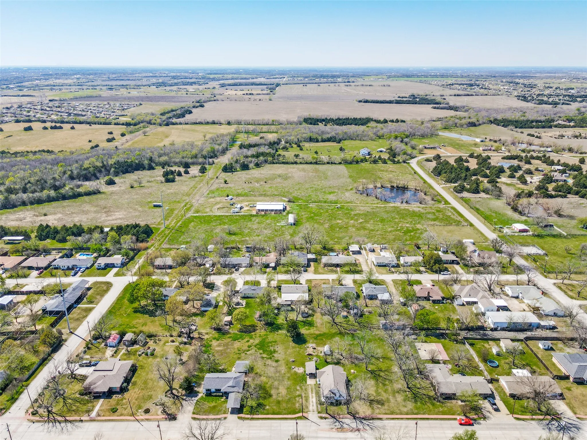 Aerial perspective showcasing a residential area bordered by expansive undeveloped land