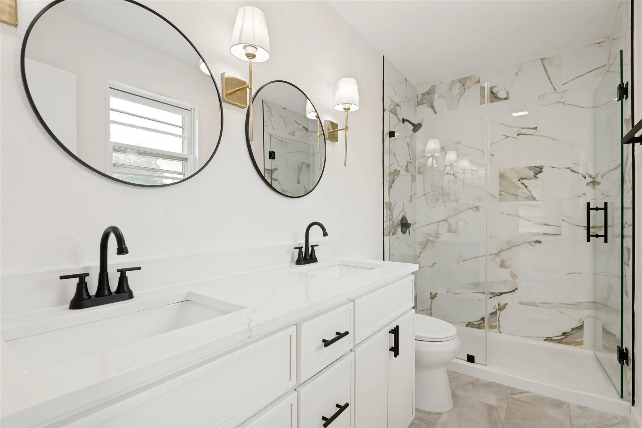 Dual vanity featuring undermount sinks, matte black faucets, and white countertops