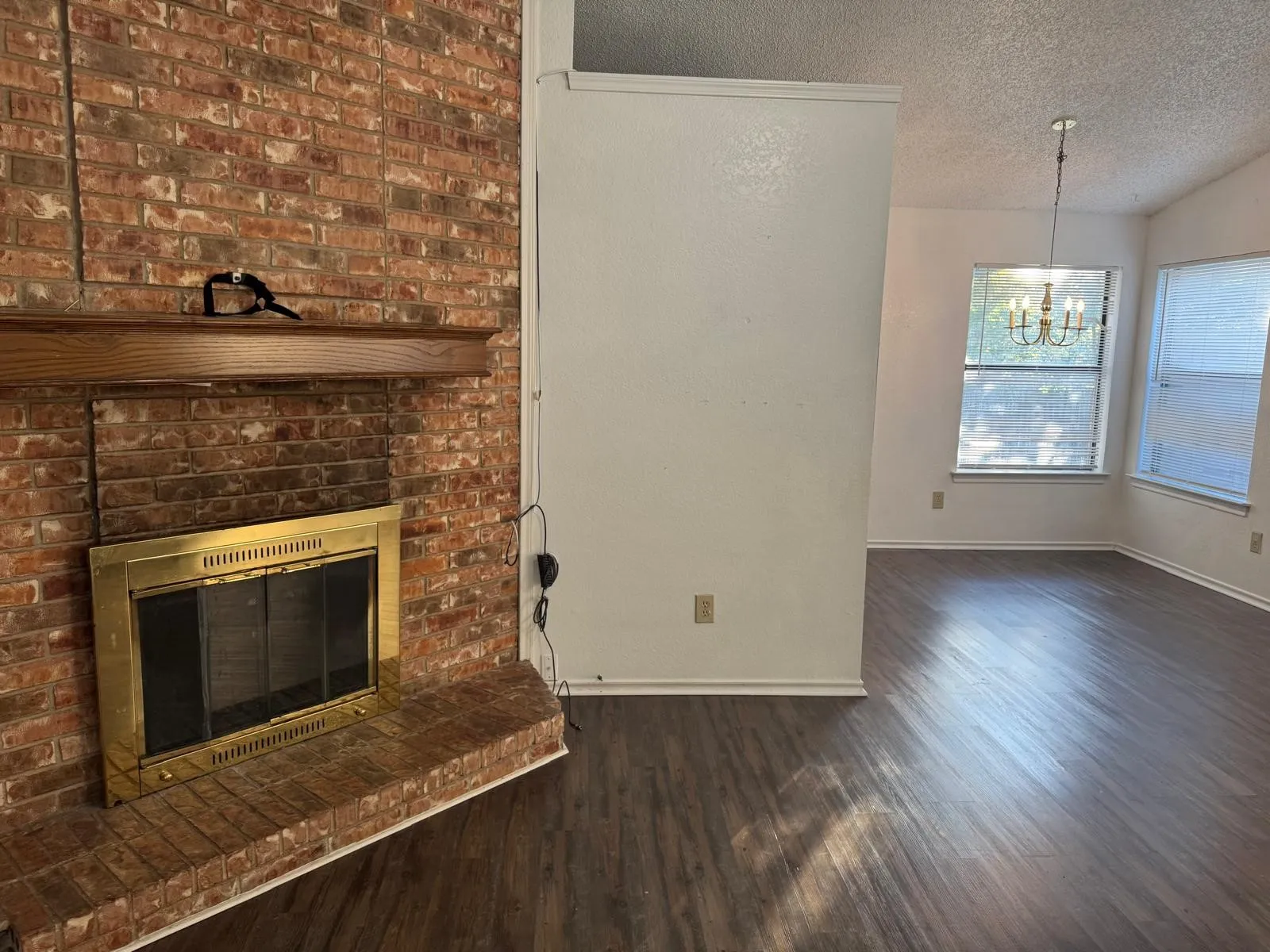 Brick fireplace with a brass firebox and wood mantel