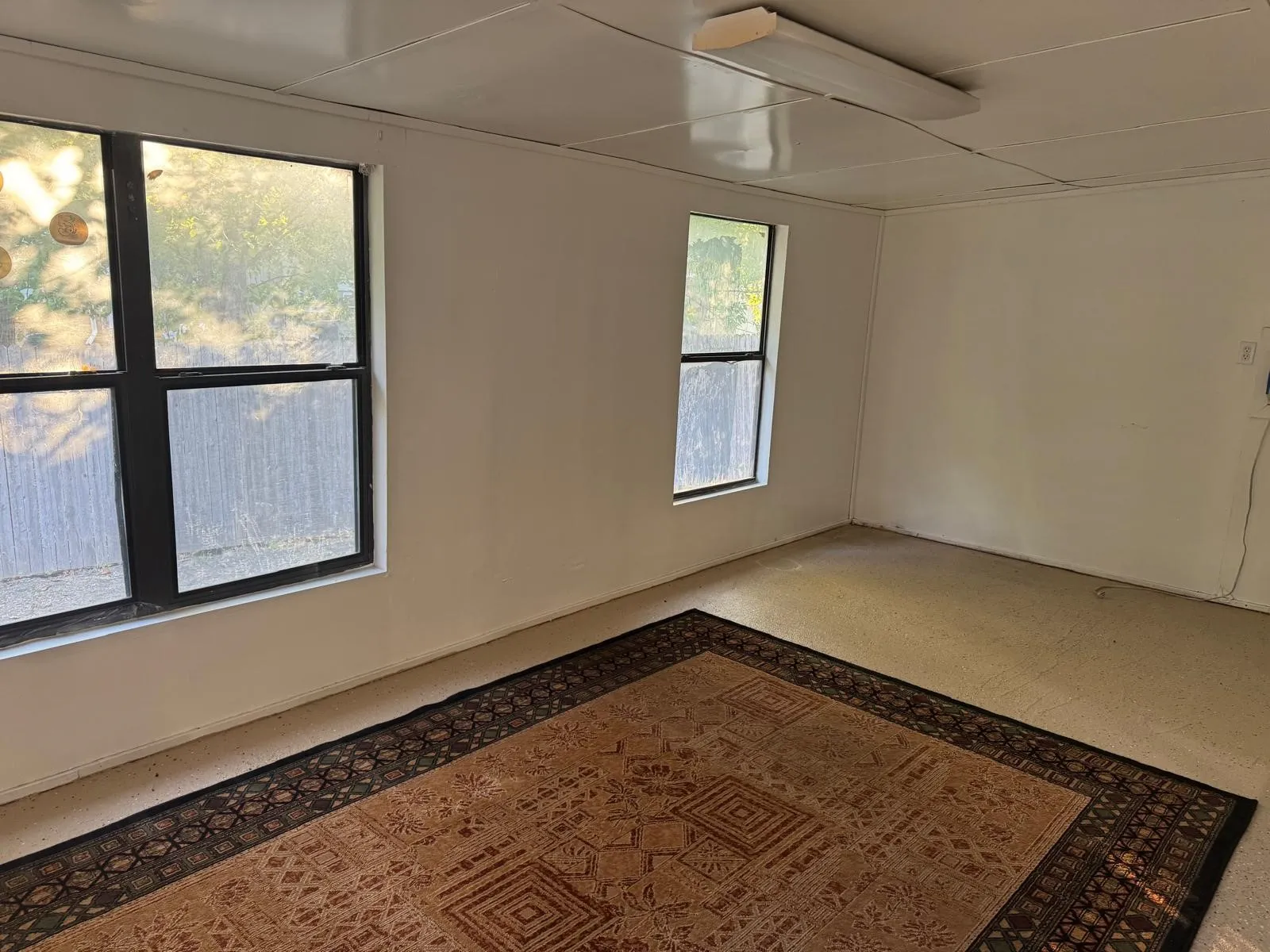 Room featuring two windows, recessed ceiling panels, and neutral wall paint