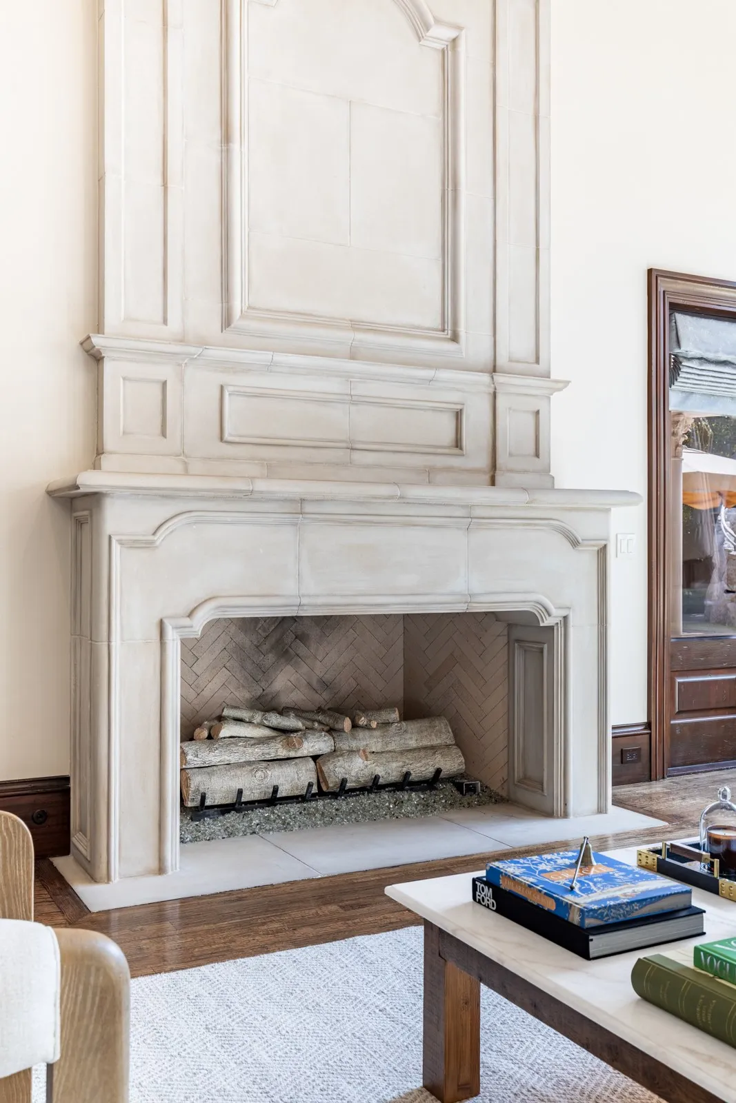 Ornate gas log fireplace with cast concrete surround, featuring a herringbone-patterned firebox interior and a carved mantel