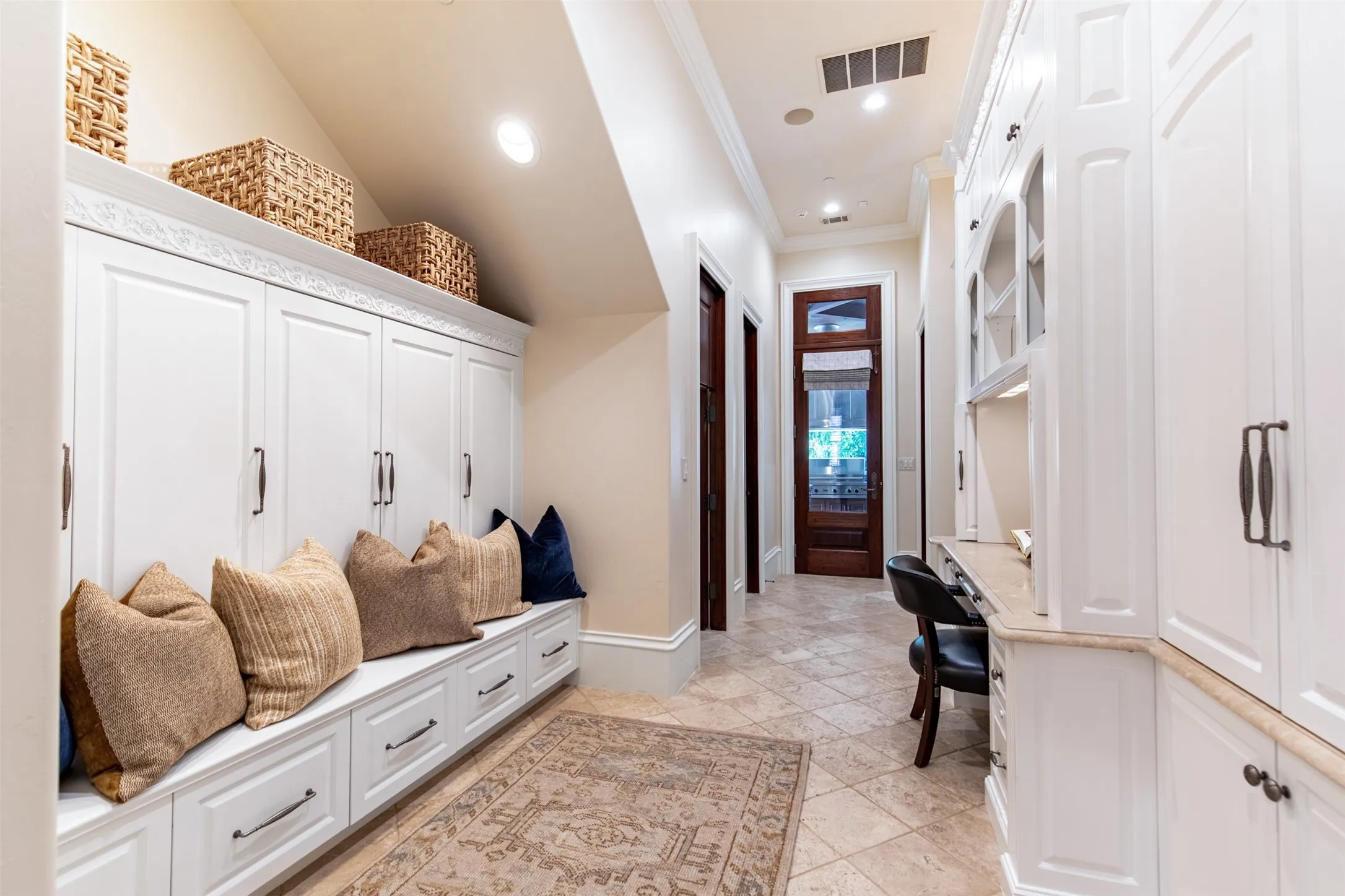 Planning desk with built-in cabinets, mud bench with covered storage, dog area under the stairs and second downstairs powder bathroom
