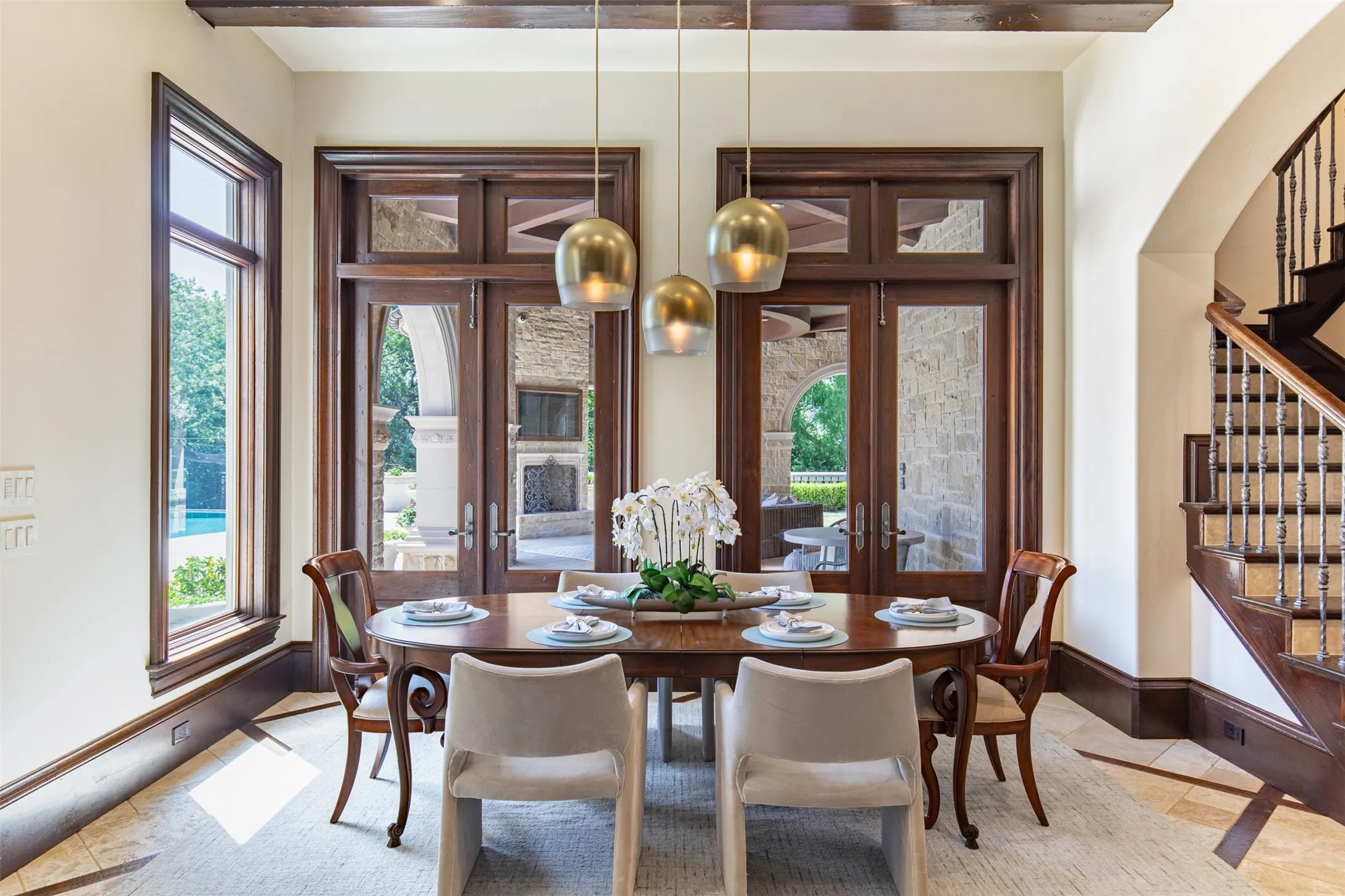 Kitchen nook featuring wood-trim windows and glass-paned double doors overlooking the lanai