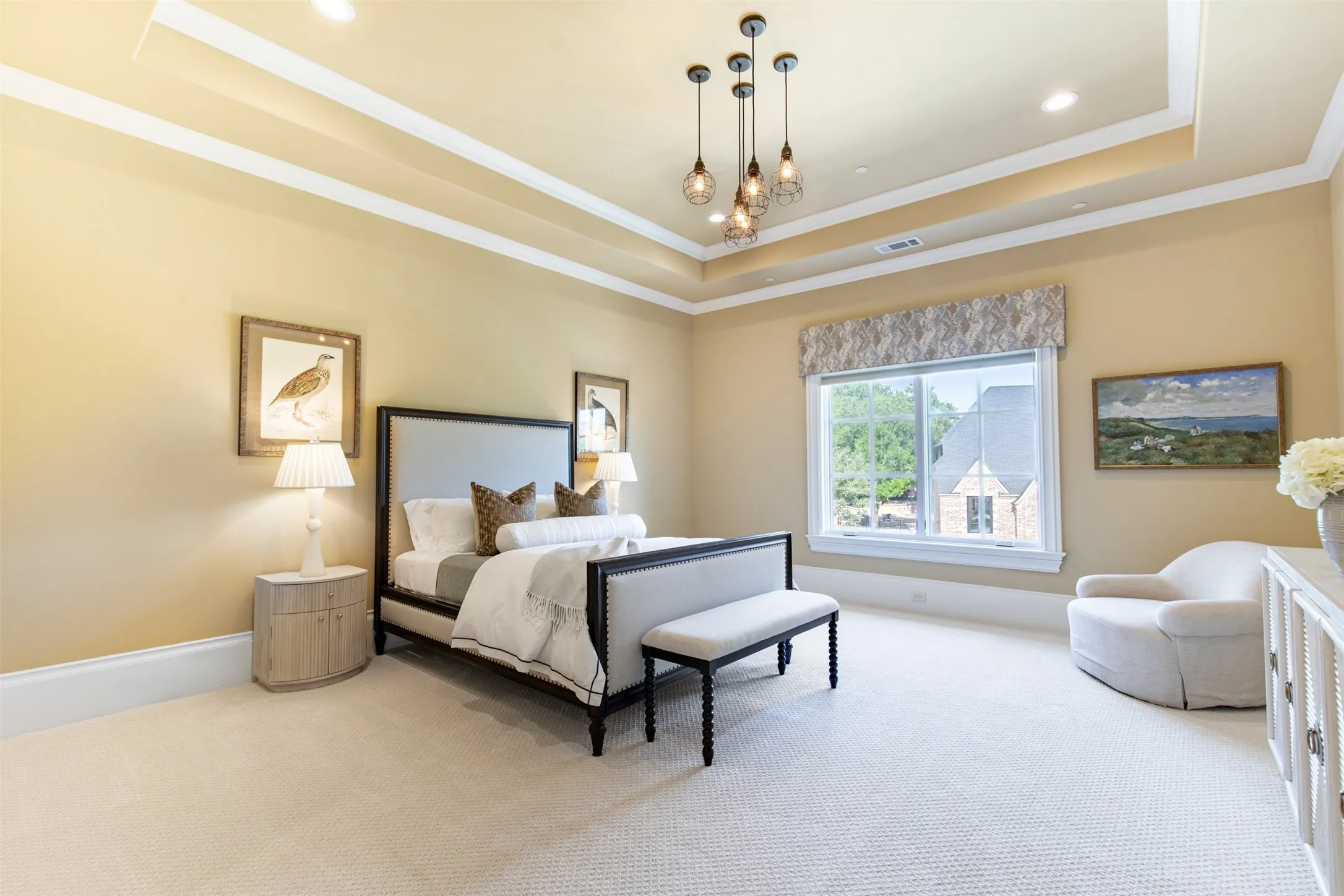 Upstairs secondary bedroom large enough for a primary bedroom featuring a double tray ceiling with recessed lighting and a multi-light pendant fixture. Features ensuite bathroom, walk-in-closet and desk area.