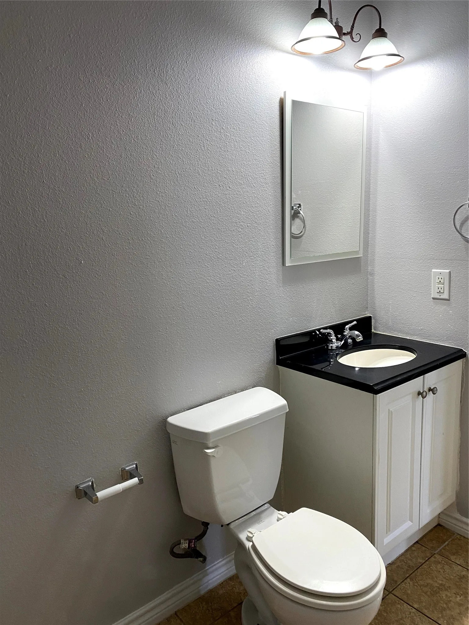 Bathroom featuring a white vanity with black countertop, built-in sink, and chrome faucet