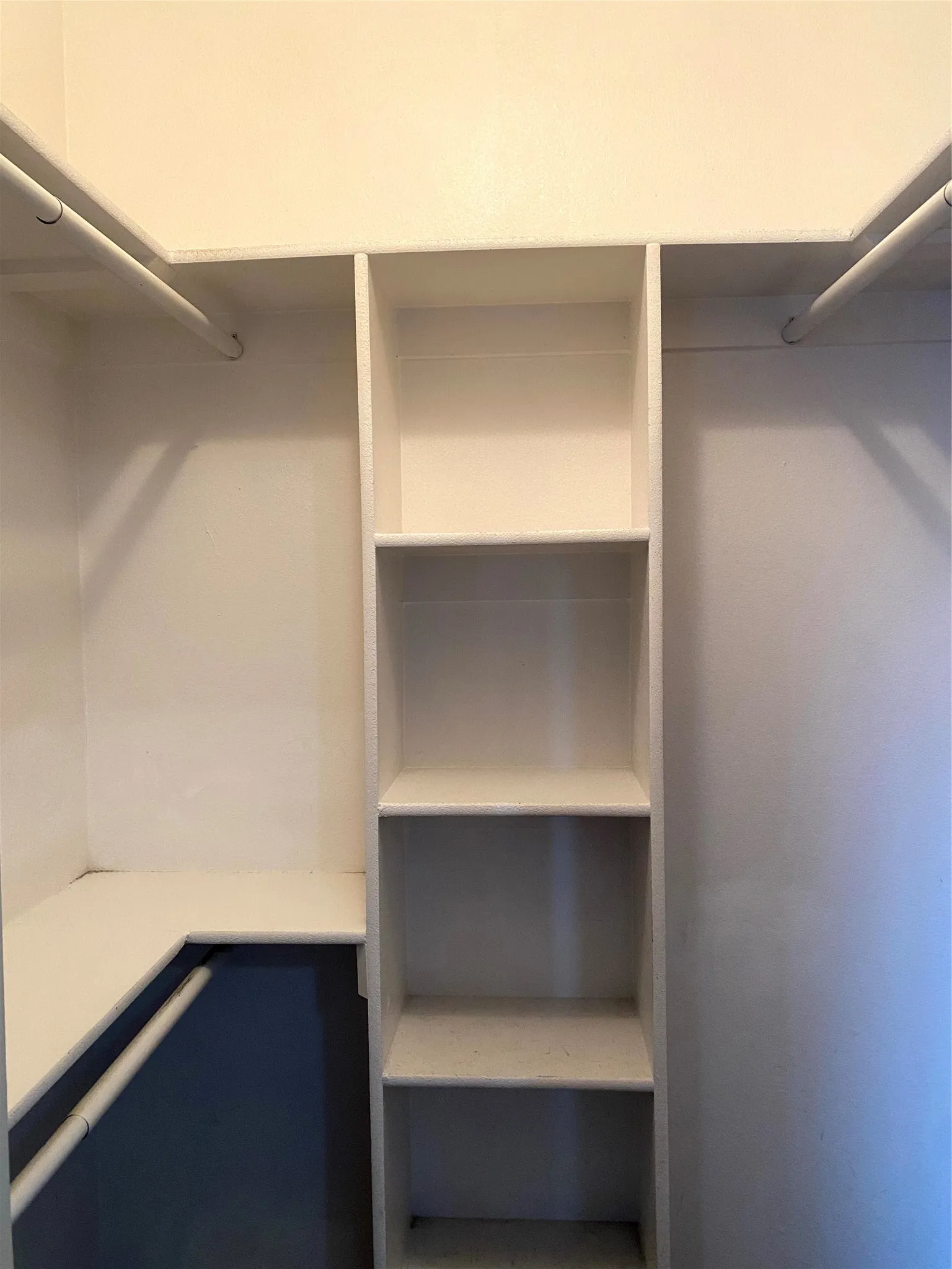 Built-in closet shelving system featuring multiple storage rods and adjustable shelves