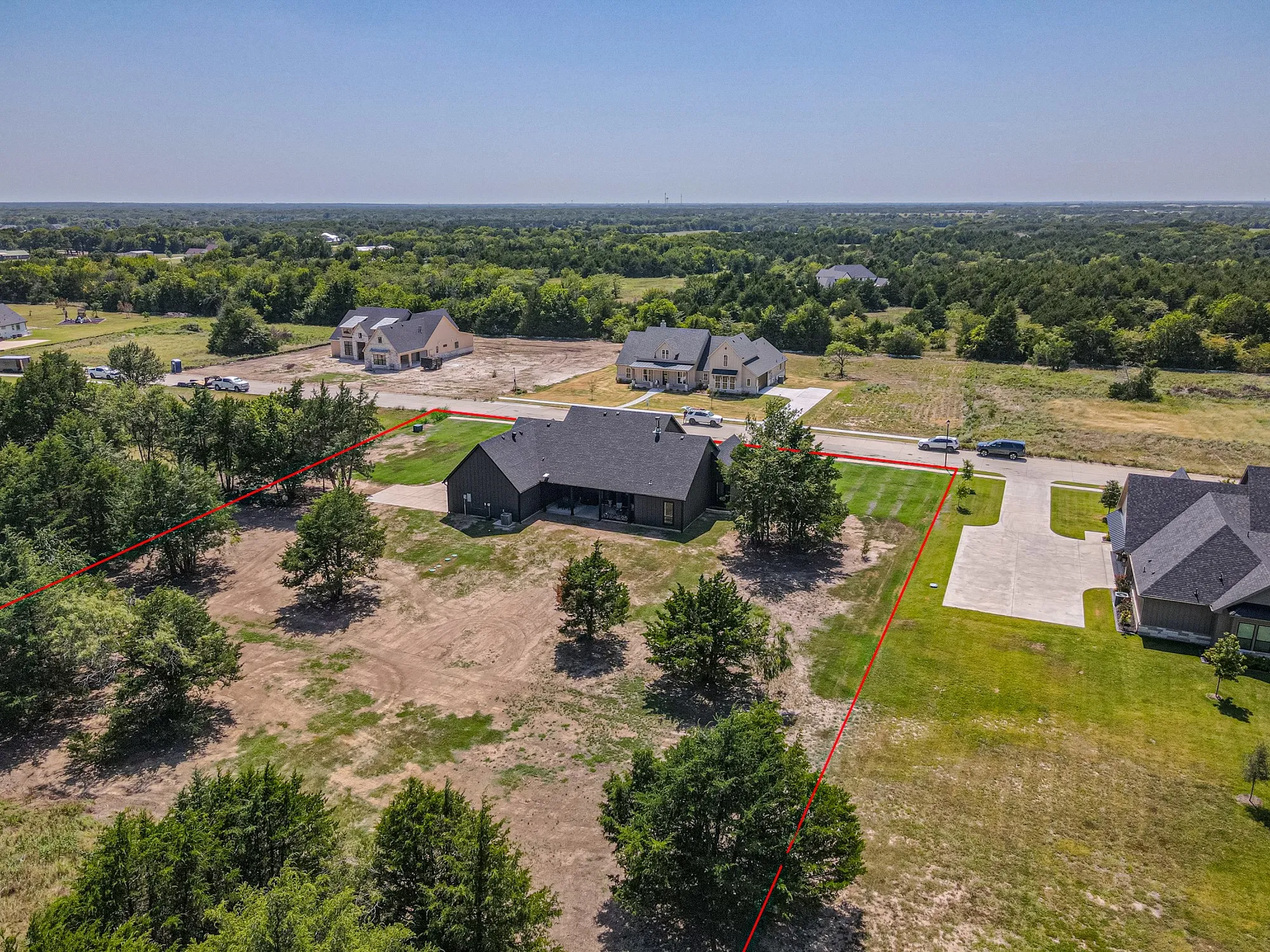Single-story residence with a dark-toned exterior and a covered patio, situated on a substantial lot