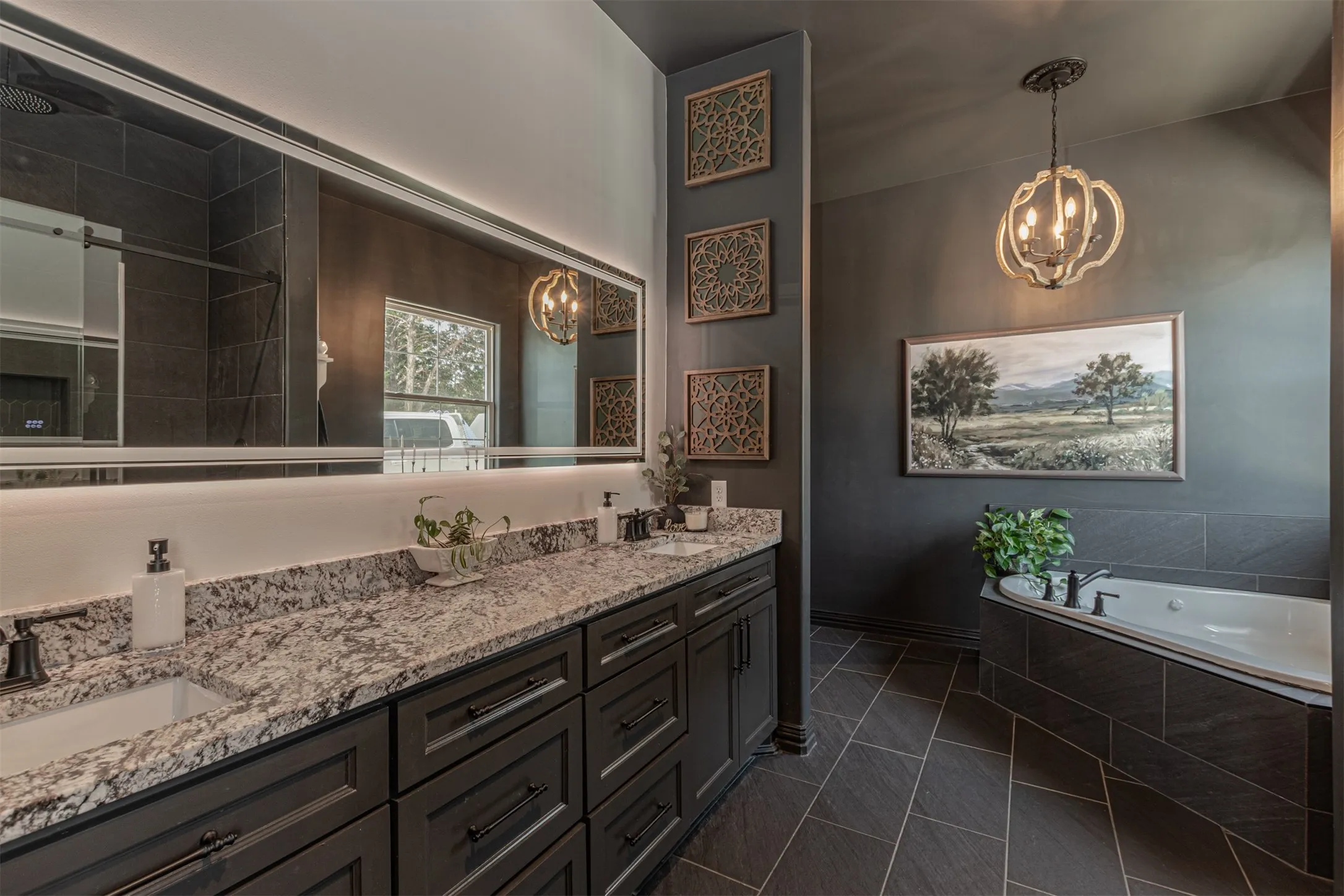 Spacious bathroom featuring a dual vanity with granite countertop, dark wood cabinetry, and integrated sinks