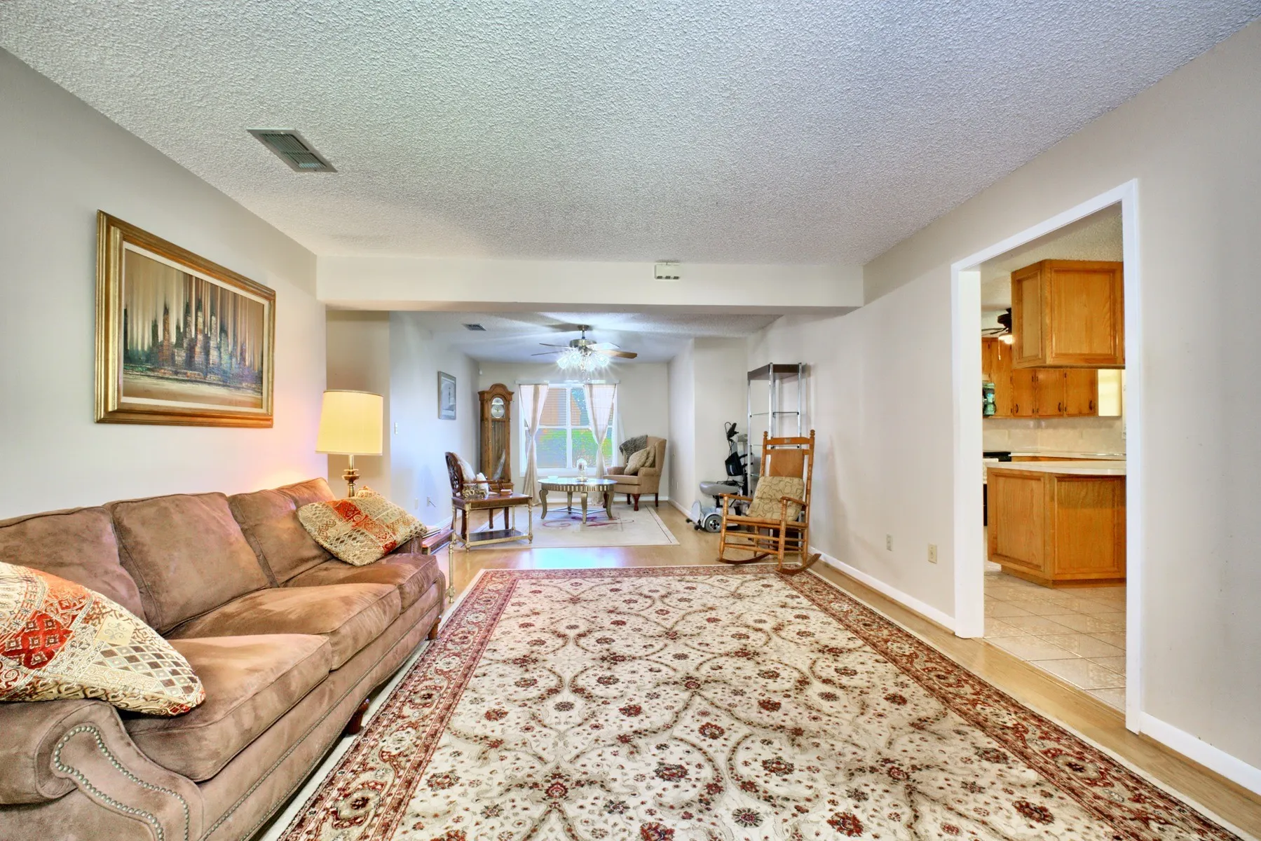 Light-colored walls throughout enhance the living space, featuring wood-finish flooring