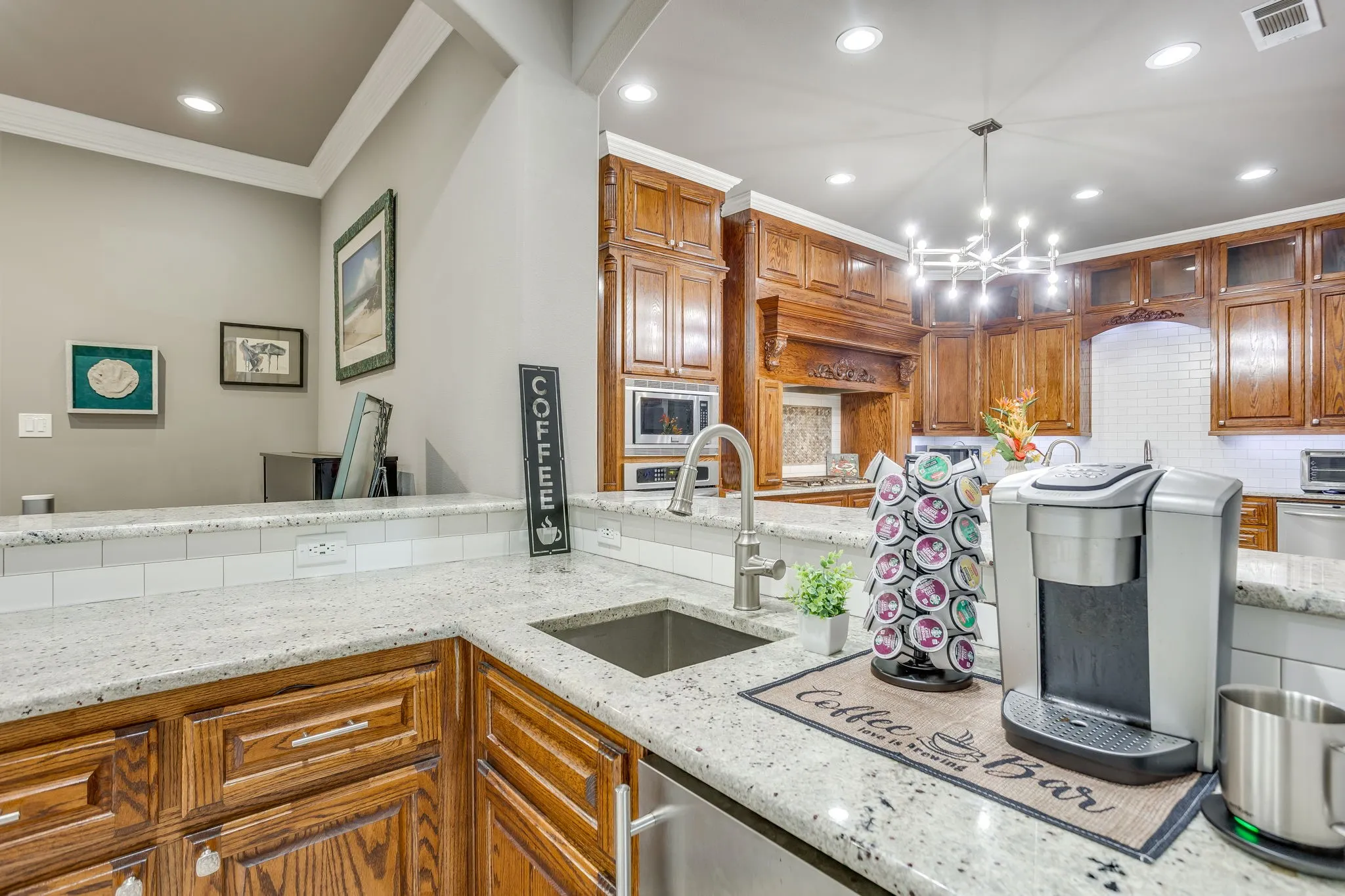 Kitchen featuring granite countertops, undermount stainless steel sink with gooseneck faucet, subway tile backsplash, and recessed lighting