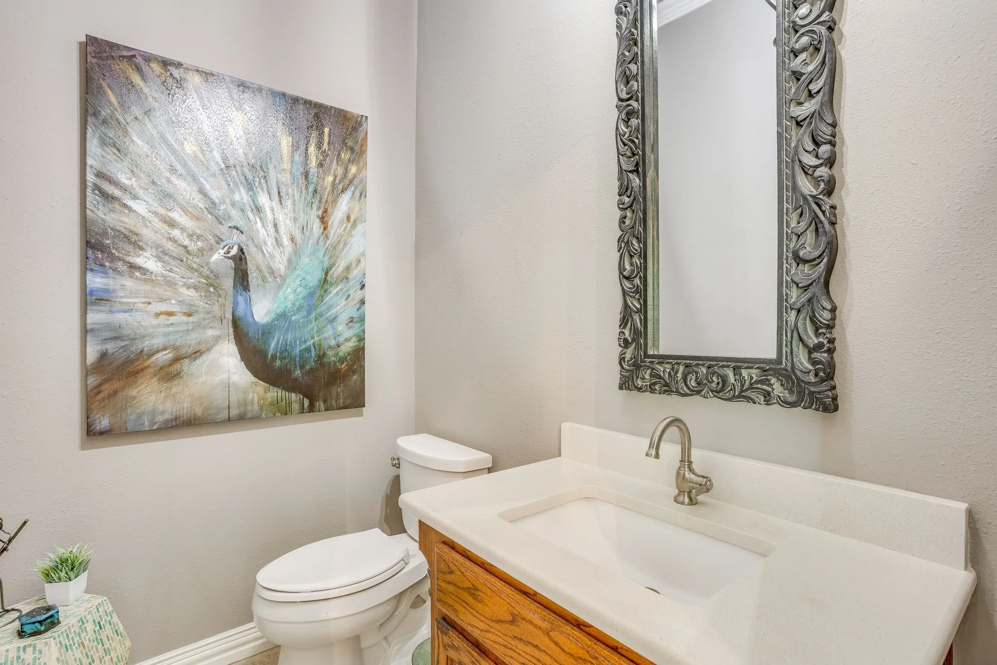Bathroom vanity featuring a single basin sink, light-toned countertop, and wood-finish cabinetry