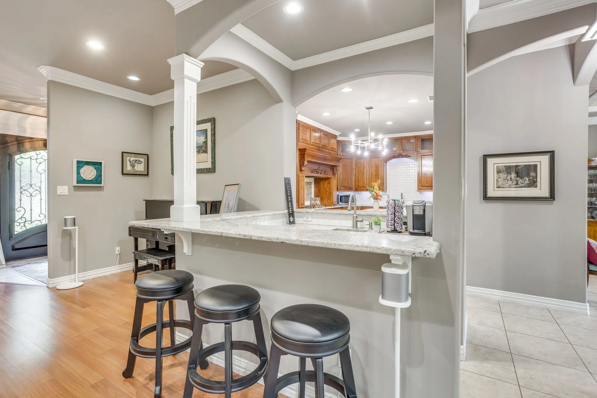 Kitchen bar area featuring a granite countertop, wood-finish flooring, recessed lighting, and crown molding
