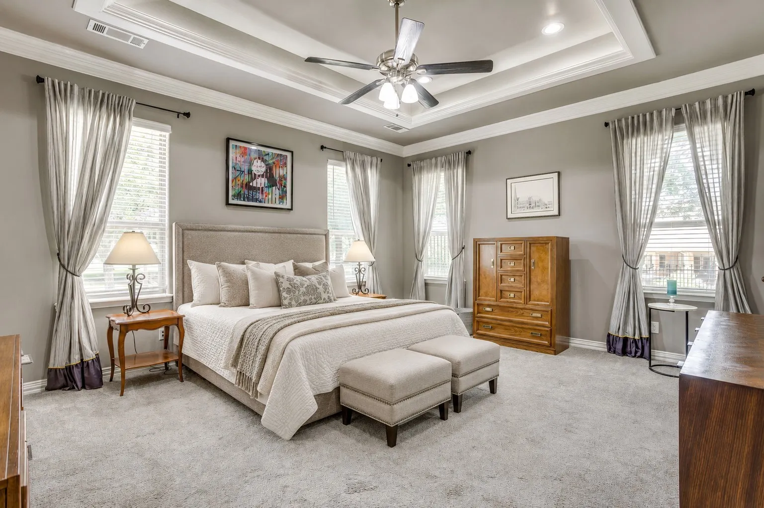 Expansive room featuring a tray ceiling with crown molding and recessed lighting