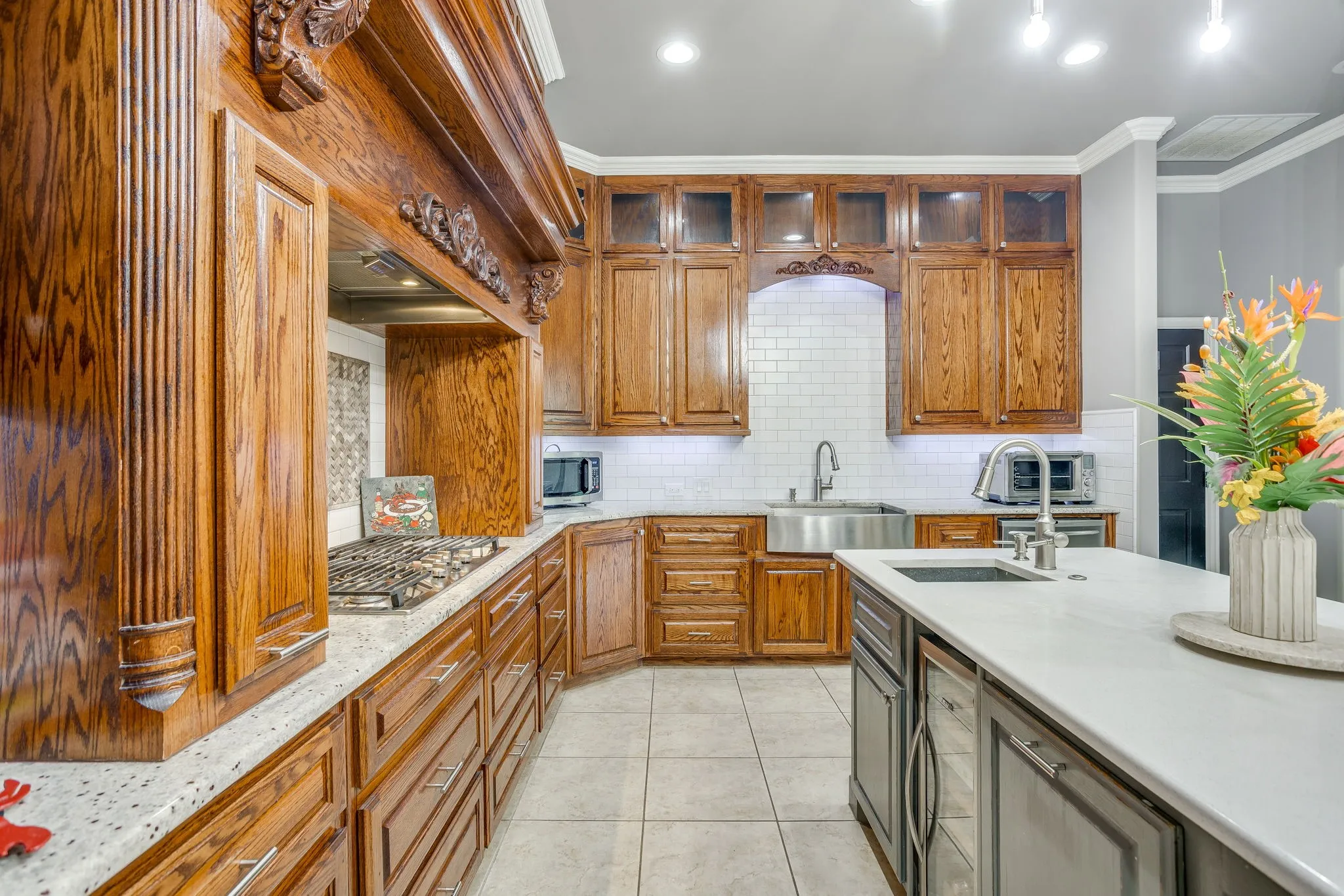 Kitchen featuring extensive wood cabinetry, light speckled countertops, and a white subway tile backsplash