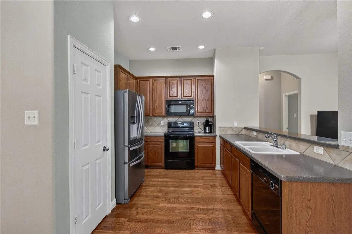 Open kitchen with corian countertops and a breakfast bar open to the living room