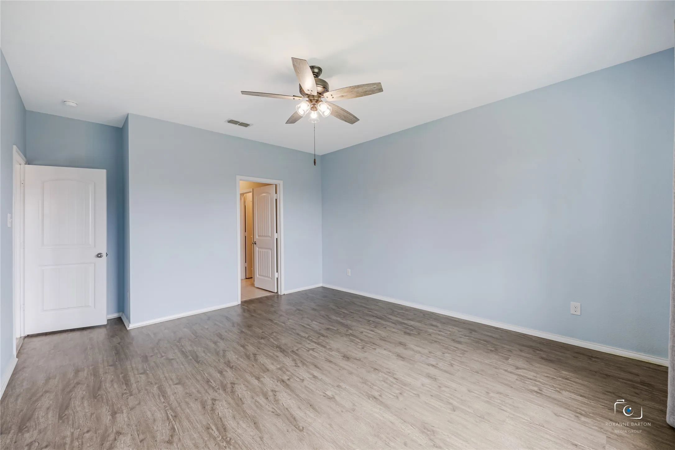This King sized primary suite features a ceiling fan and an ensuite bathroom