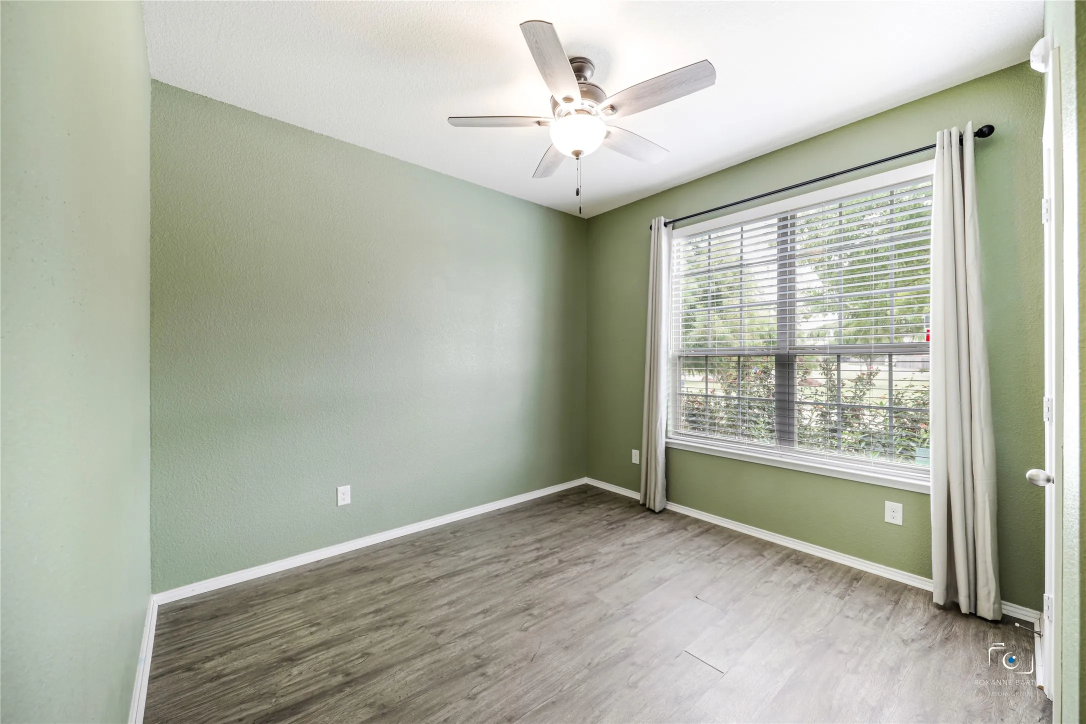 This front bedroom with double windows looks to the front landscaping and park across the street.