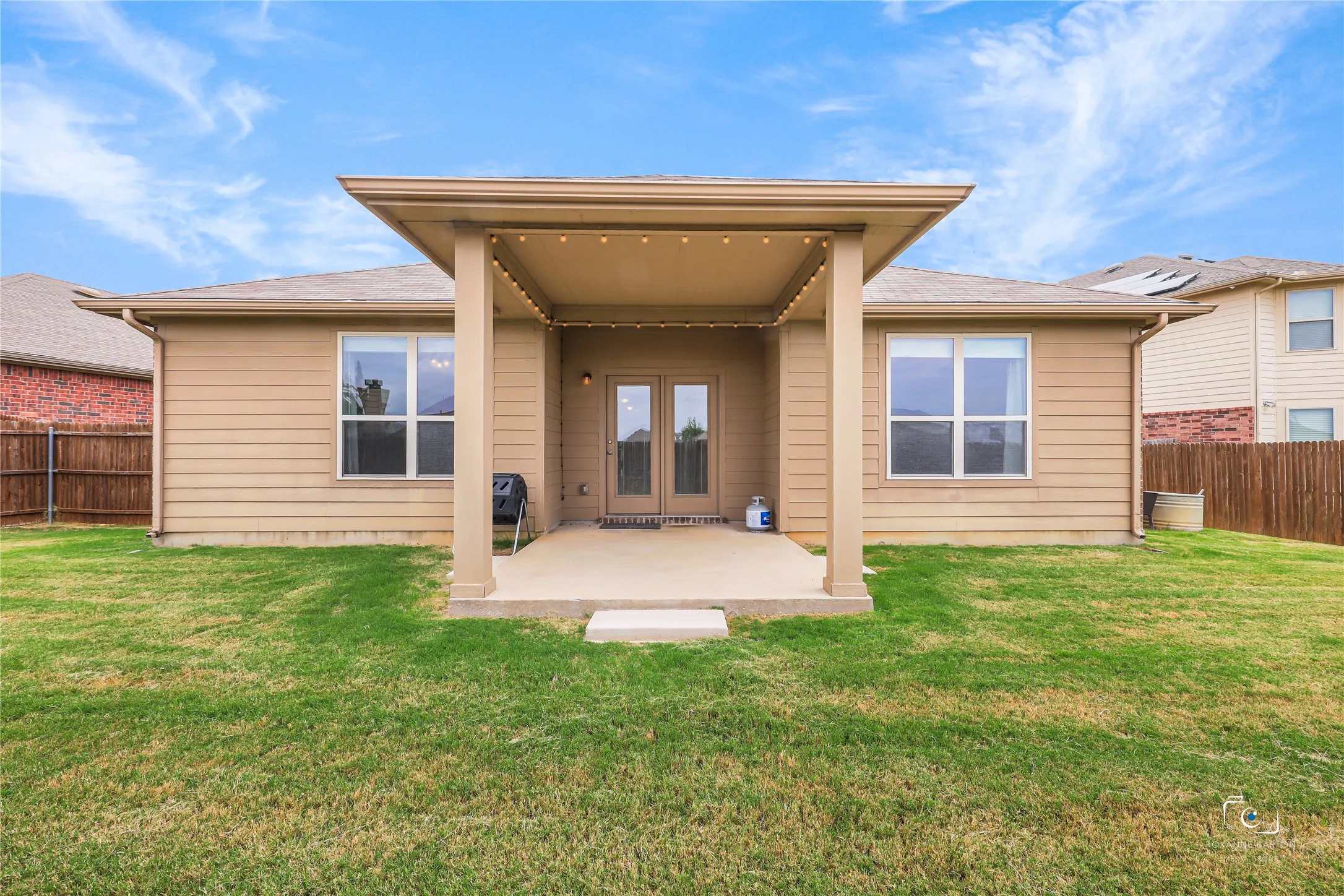 Back of home with a large covered patio. Note the gutters