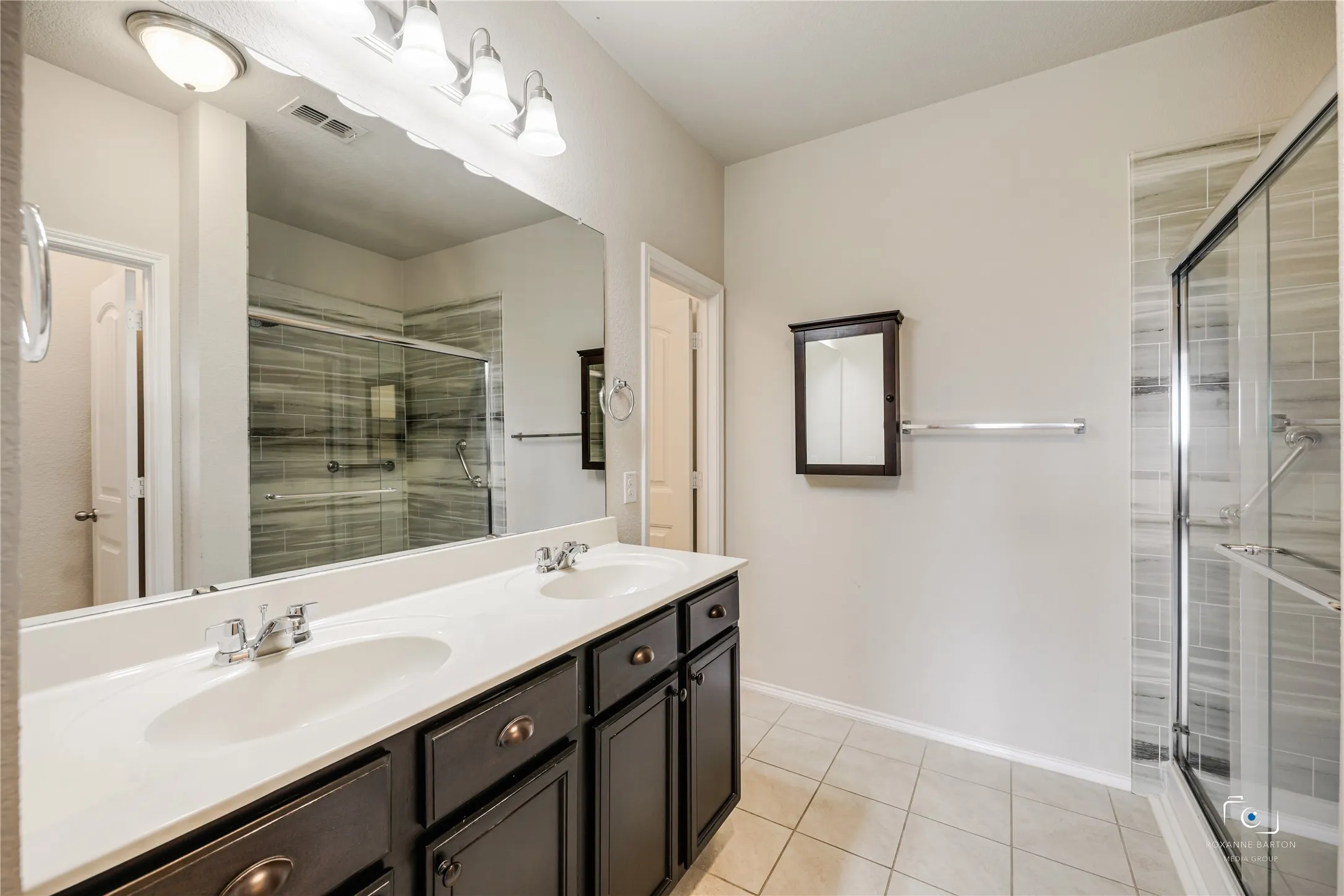 This ensuite bathroom features double sinks and a large walk-in shower