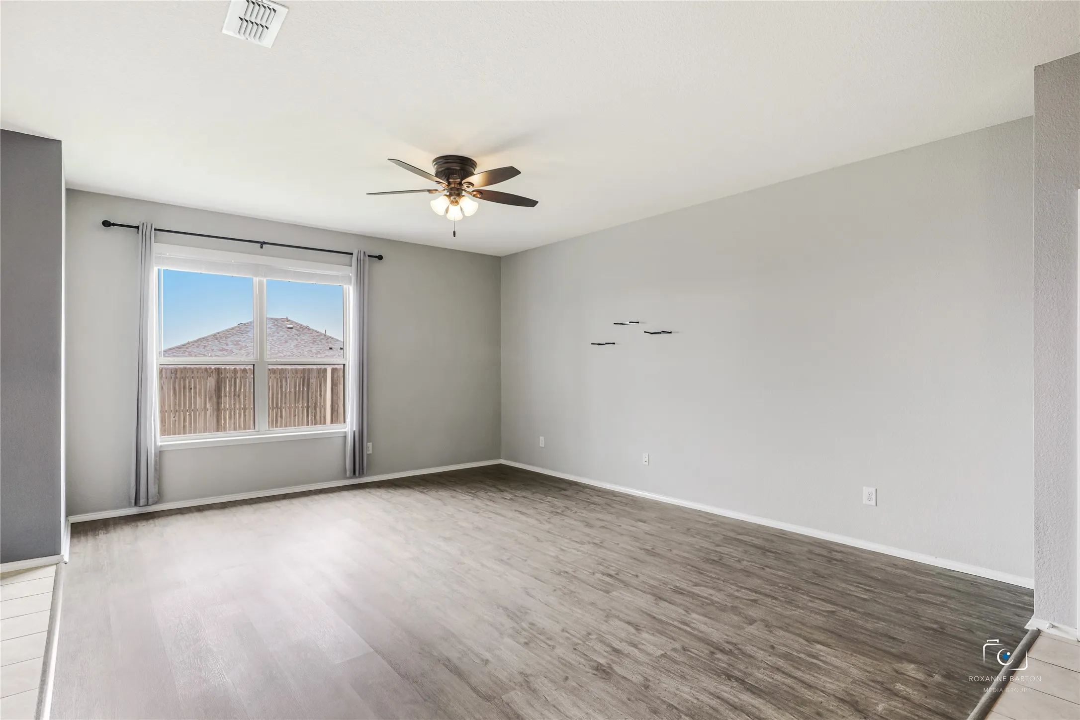 Living area with a large window view of back yard and plenty of wall space for staging your furniture