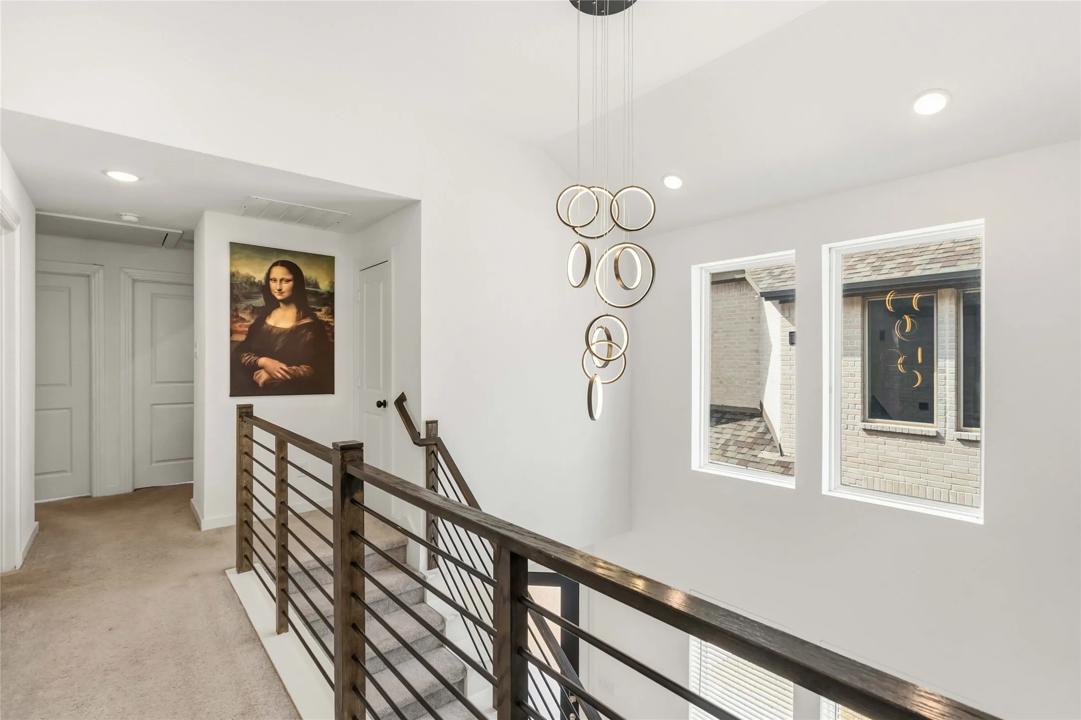 Modern chandelier with circular design elements, complement white walls and recessed lighting
