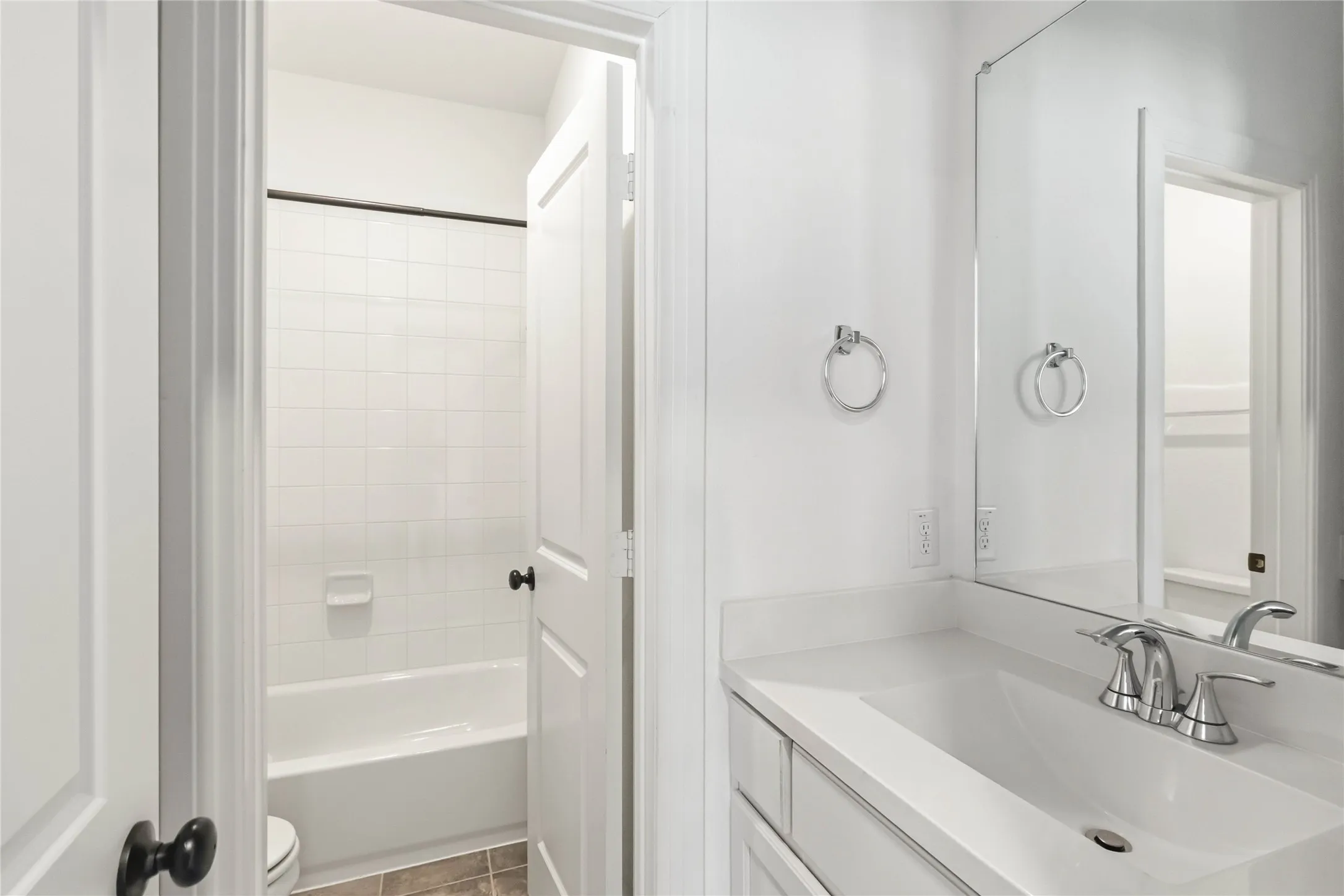 Modern bathroom featuring a single vanity with an integrated sink, polished chrome faucet, and a large wall-mounted mirror