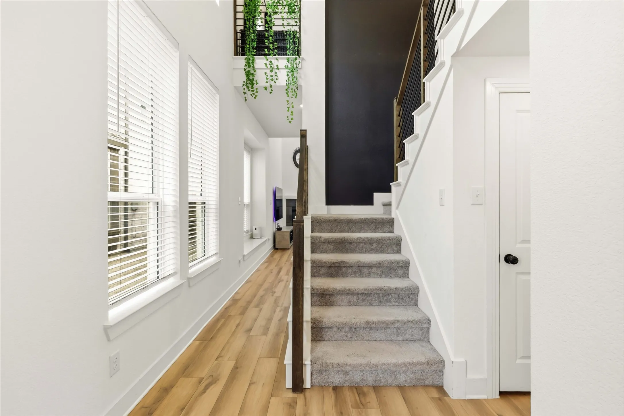 Staircase with carpeted treads and modern black metal railing