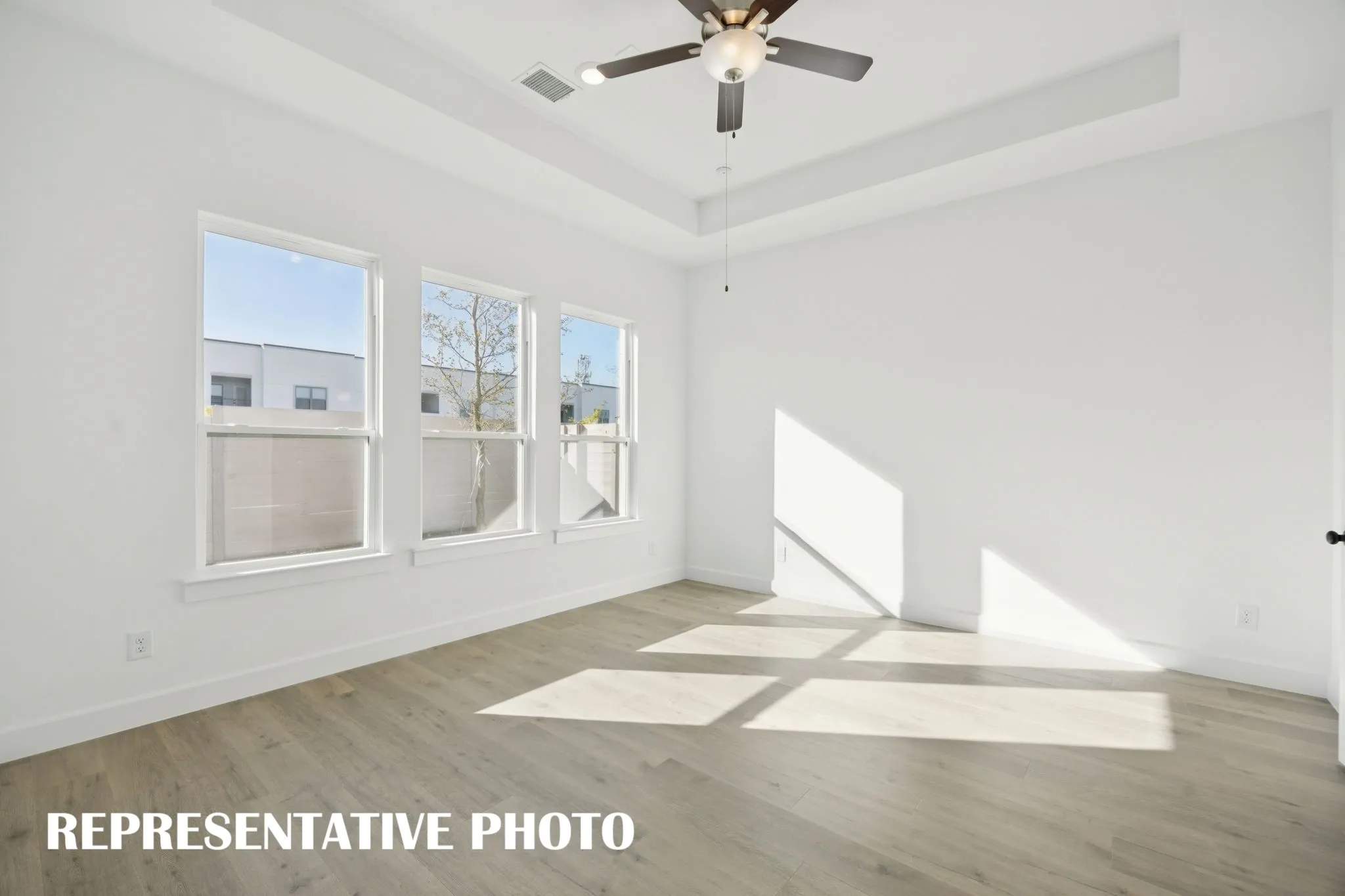 This peaceful light filled owner's bedroom is the perfect place to relax after a long day.  REPRESENTATIVE PHOTO