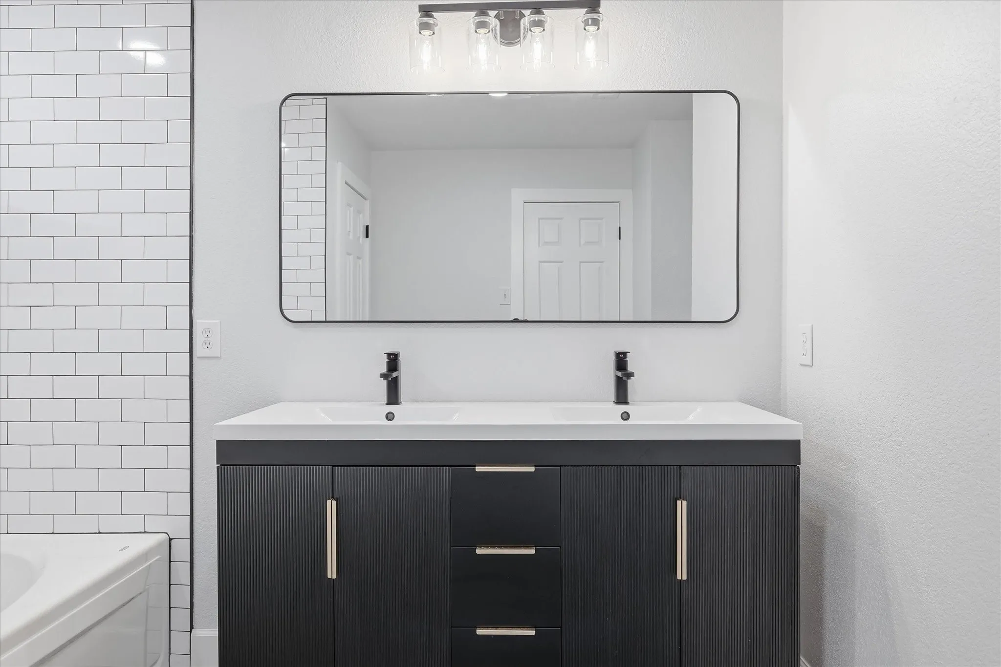 Dual-sink vanity with matte black cabinetry and brushed nickel hardware