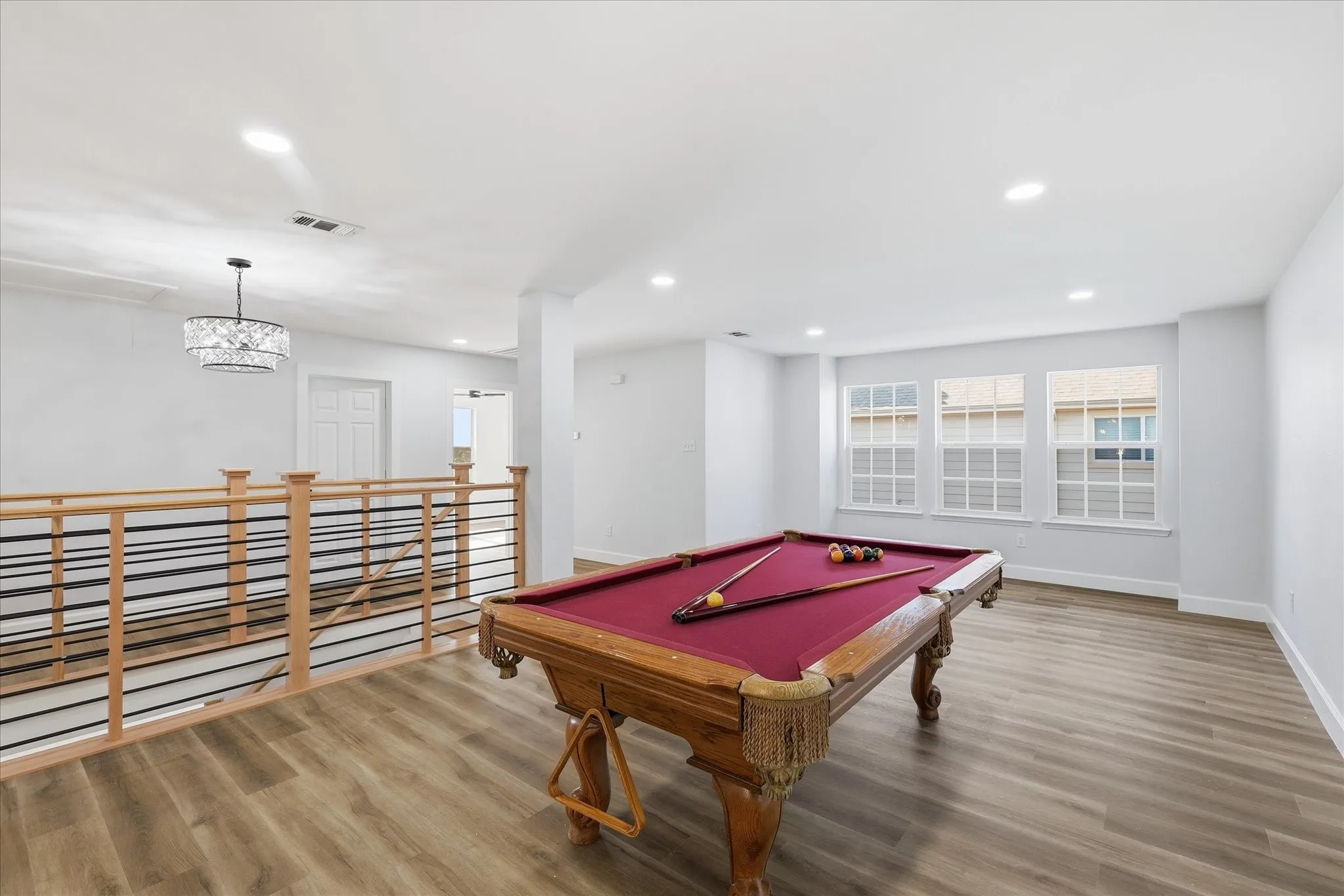Spacious open-concept room featuring wood-finish flooring and recessed lighting