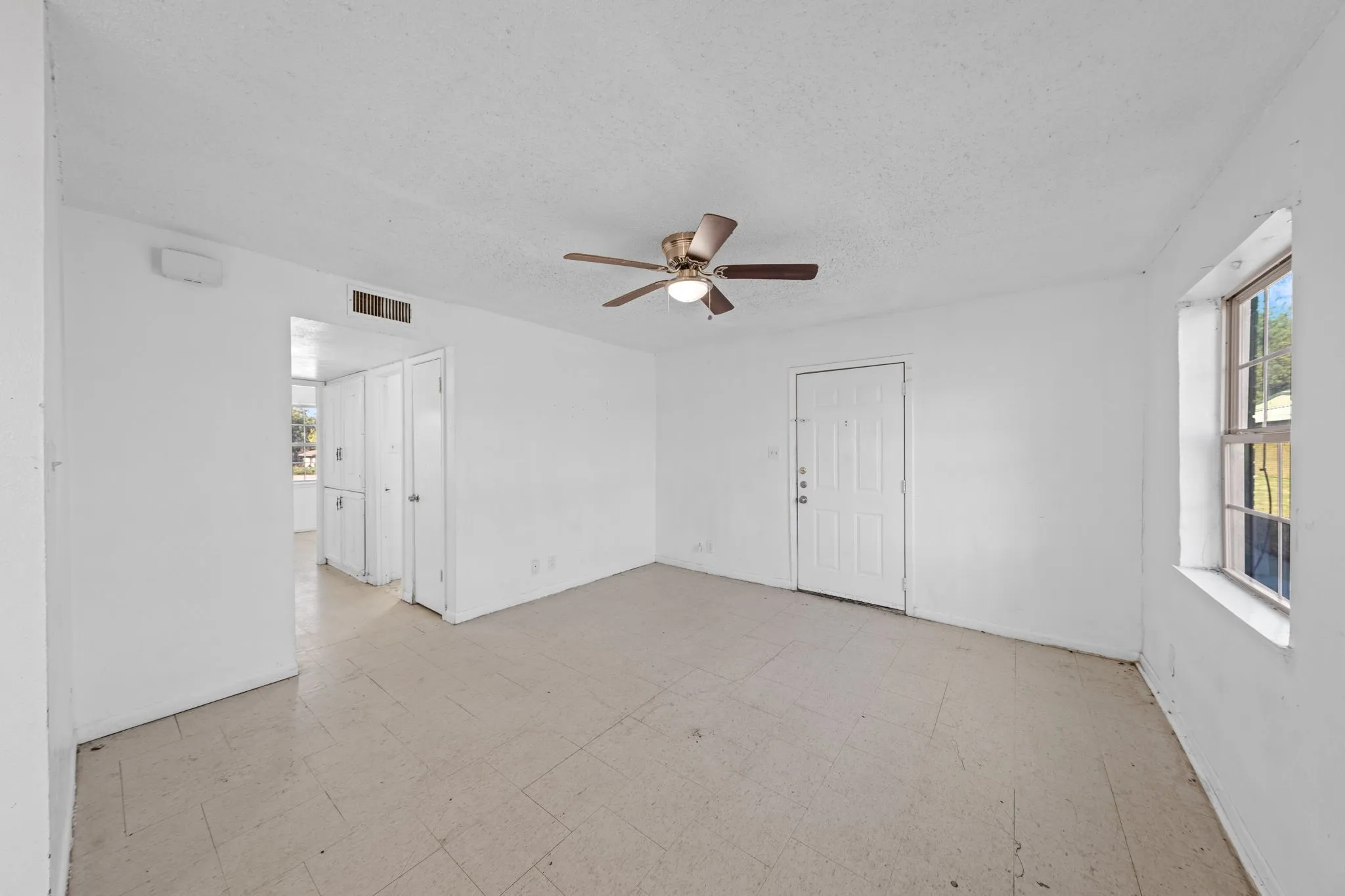 Unfurnished room featuring light flooring, a textured ceiling, and ceiling fan