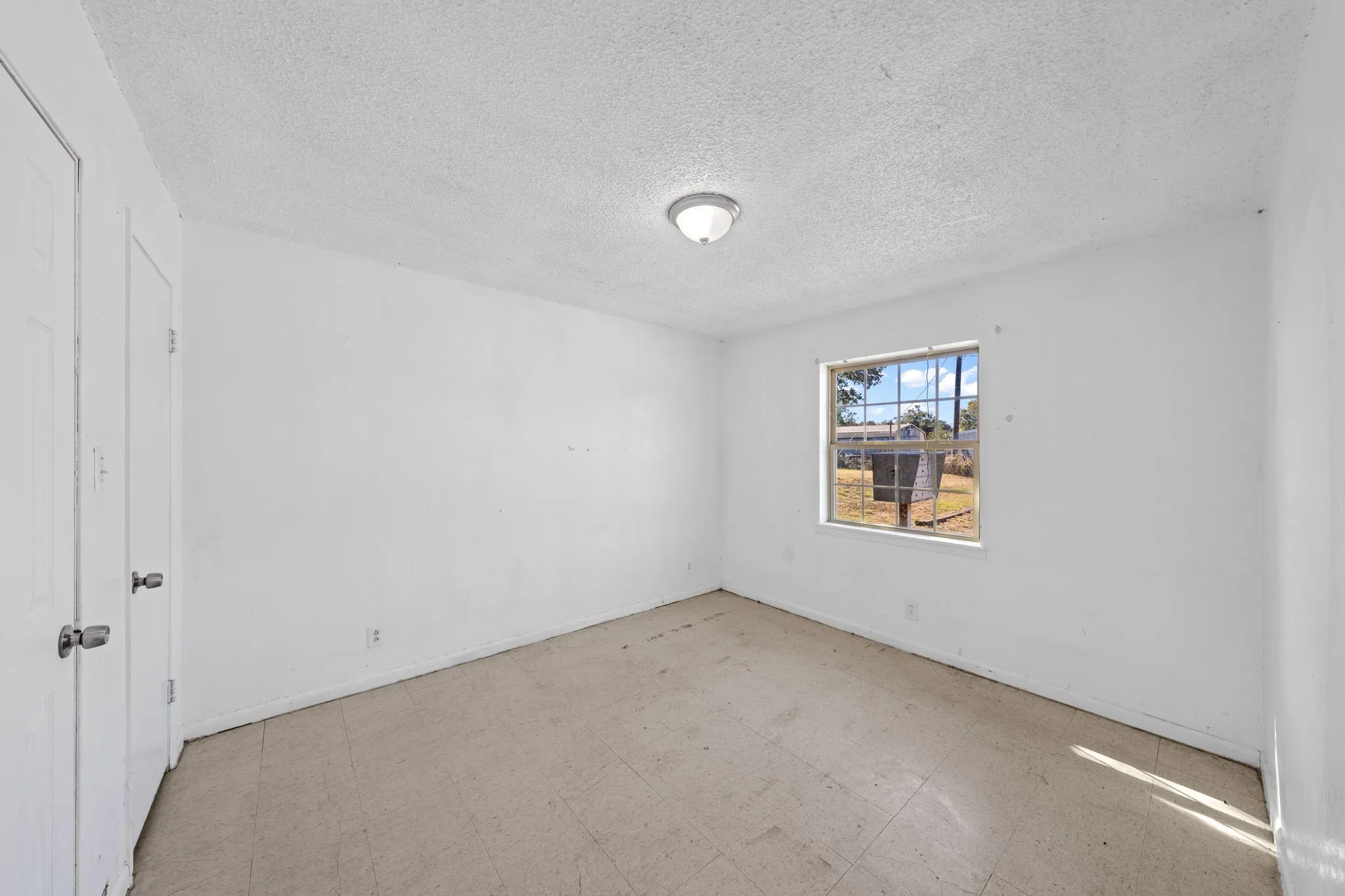 Unfurnished room with tile patterned floors and a textured ceiling