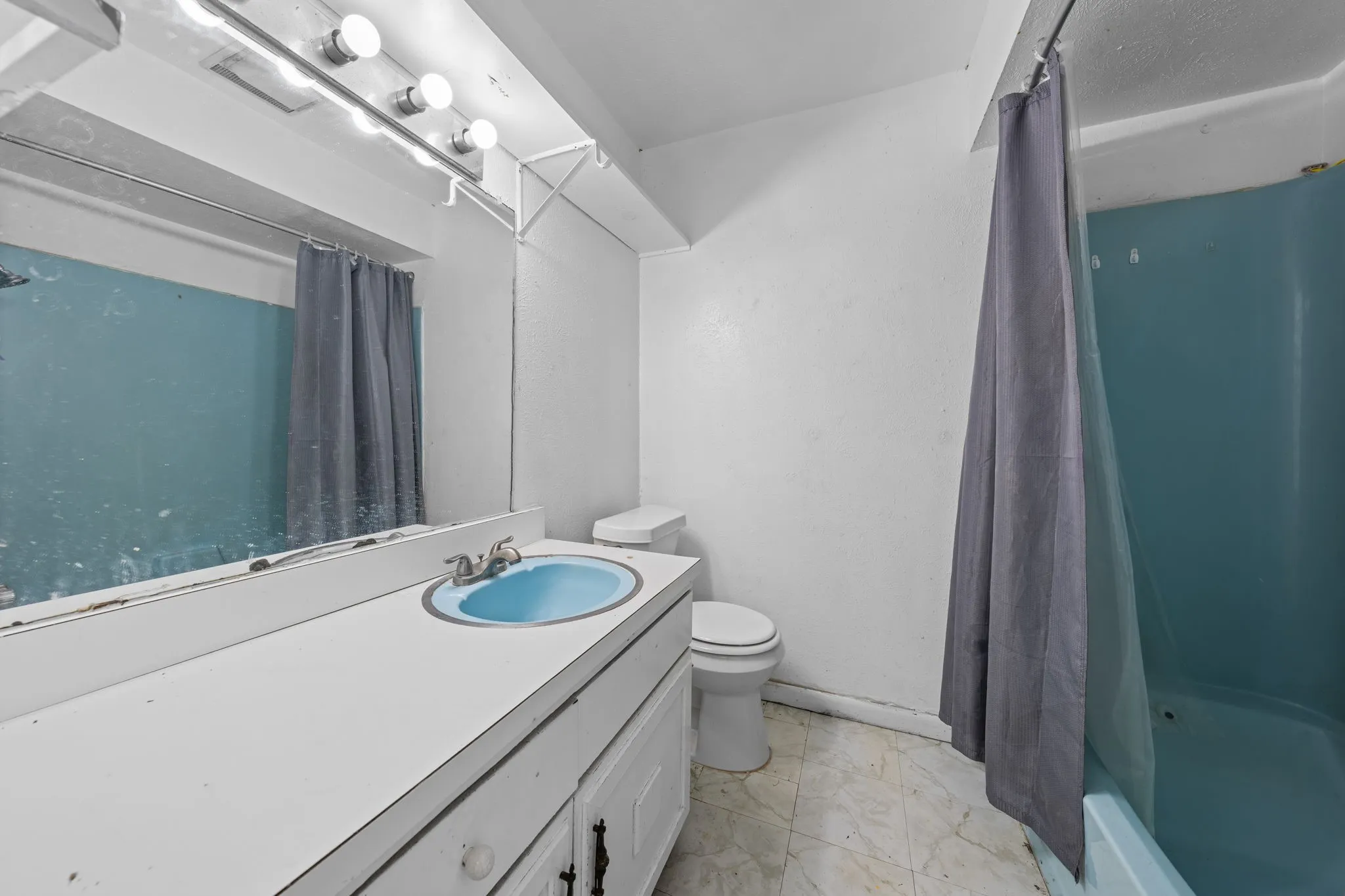 Bathroom with vanity and shower / tub combo with curtain