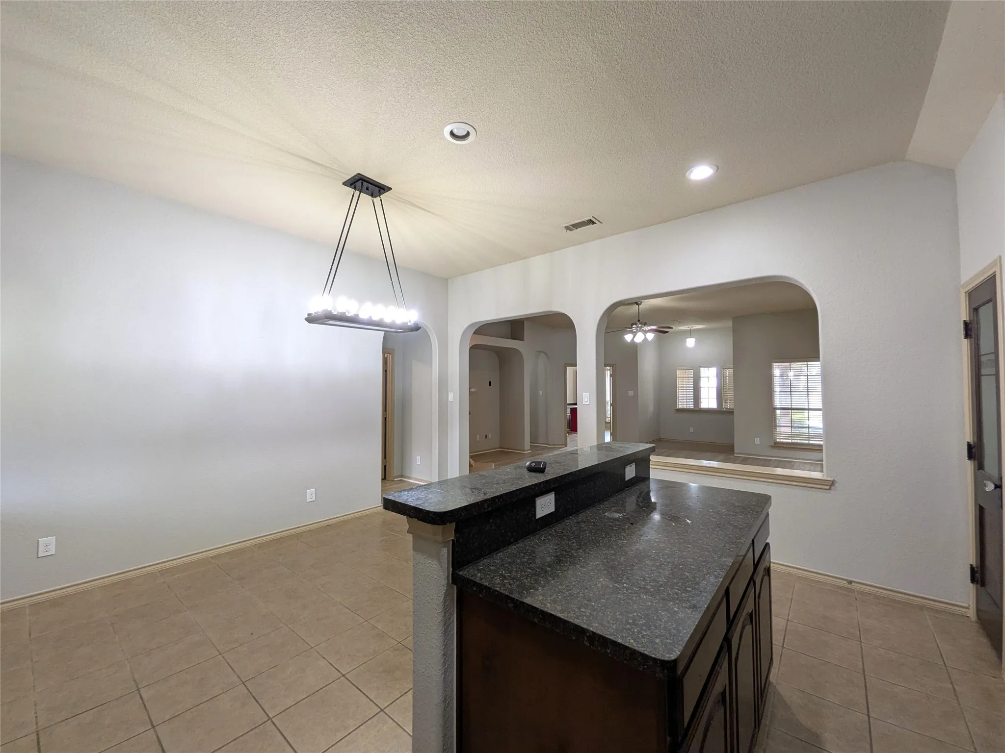 Kitchen island with dark wood cabinetry and a speckled countertop