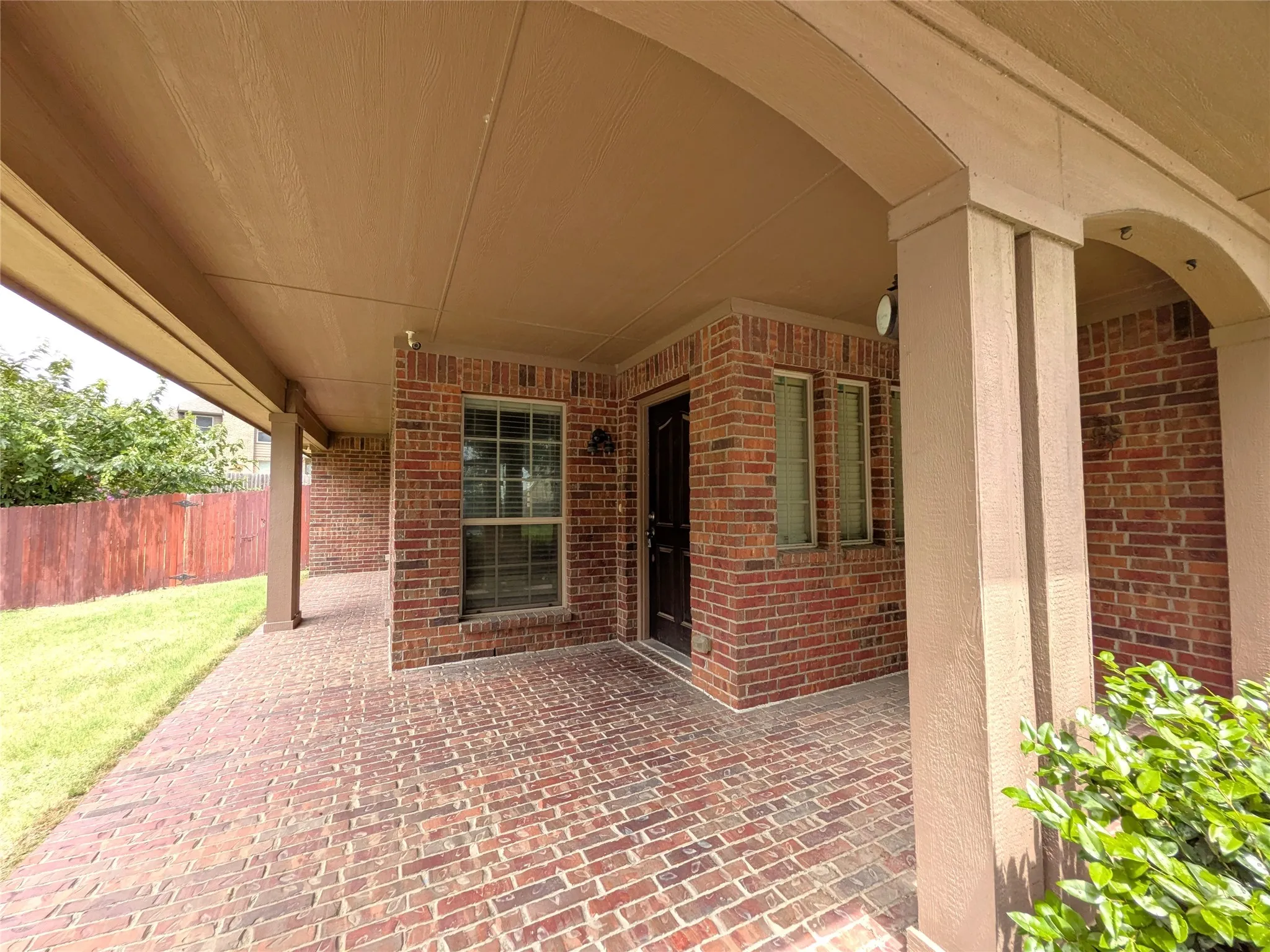Covered patio featuring brick pavers and a wood-finish ceiling