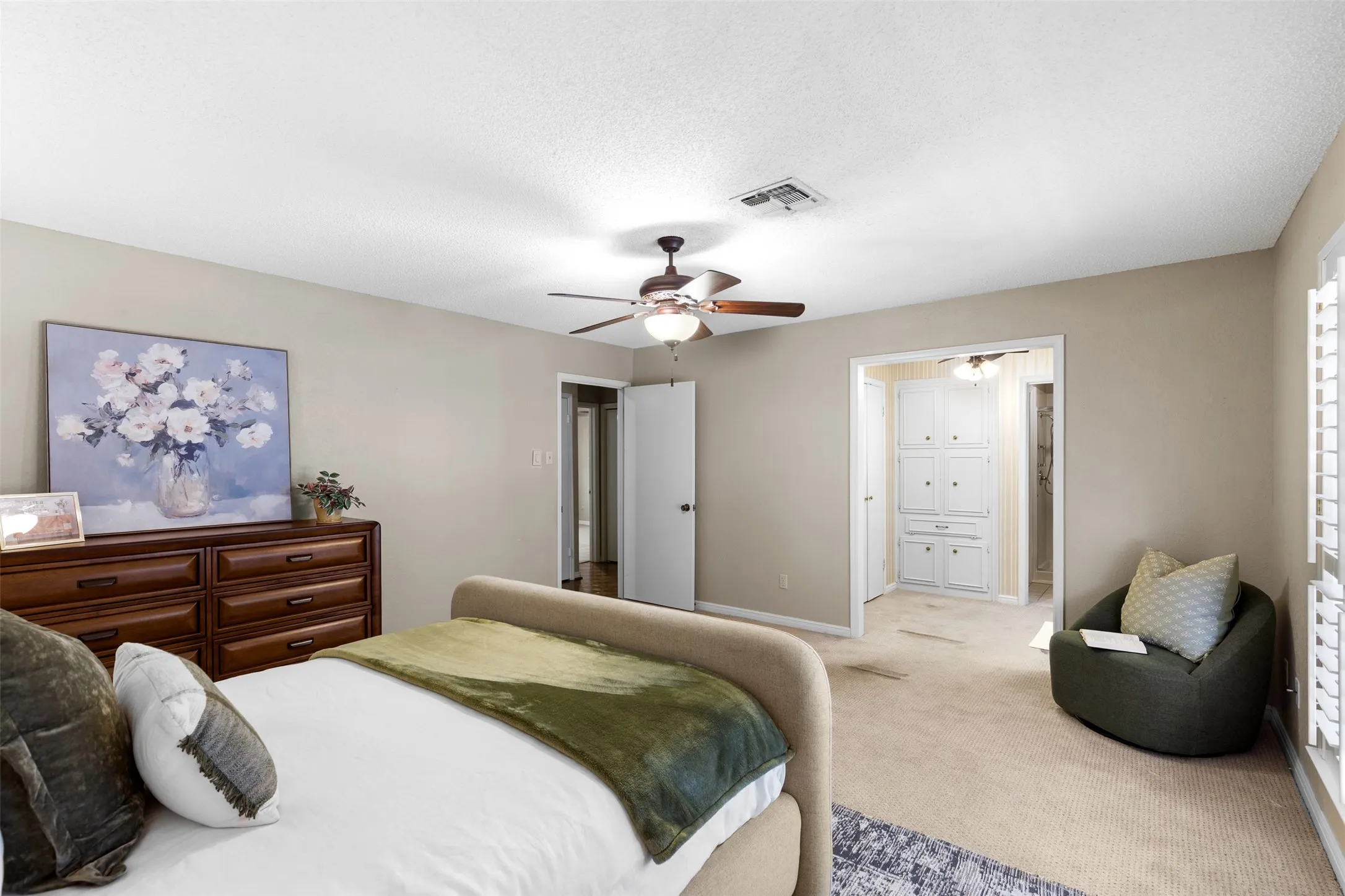 Neutral-toned walls, ceiling fan with integrated lighting, wood-finish flooring, and white plantation shutters