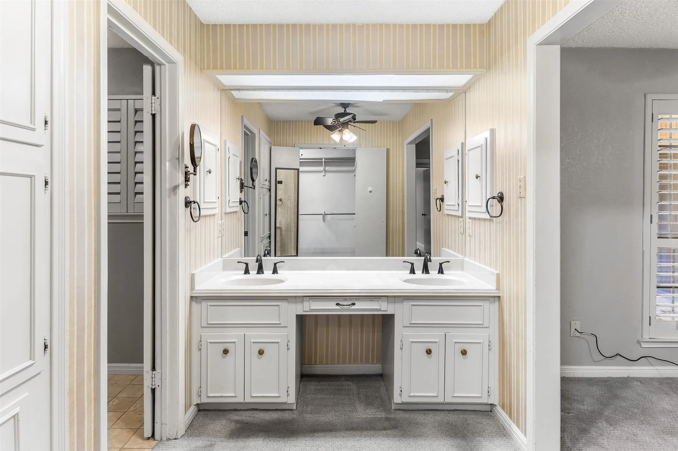 Dual vanity with integrated sinks, white cabinetry, and matte black fixtures
