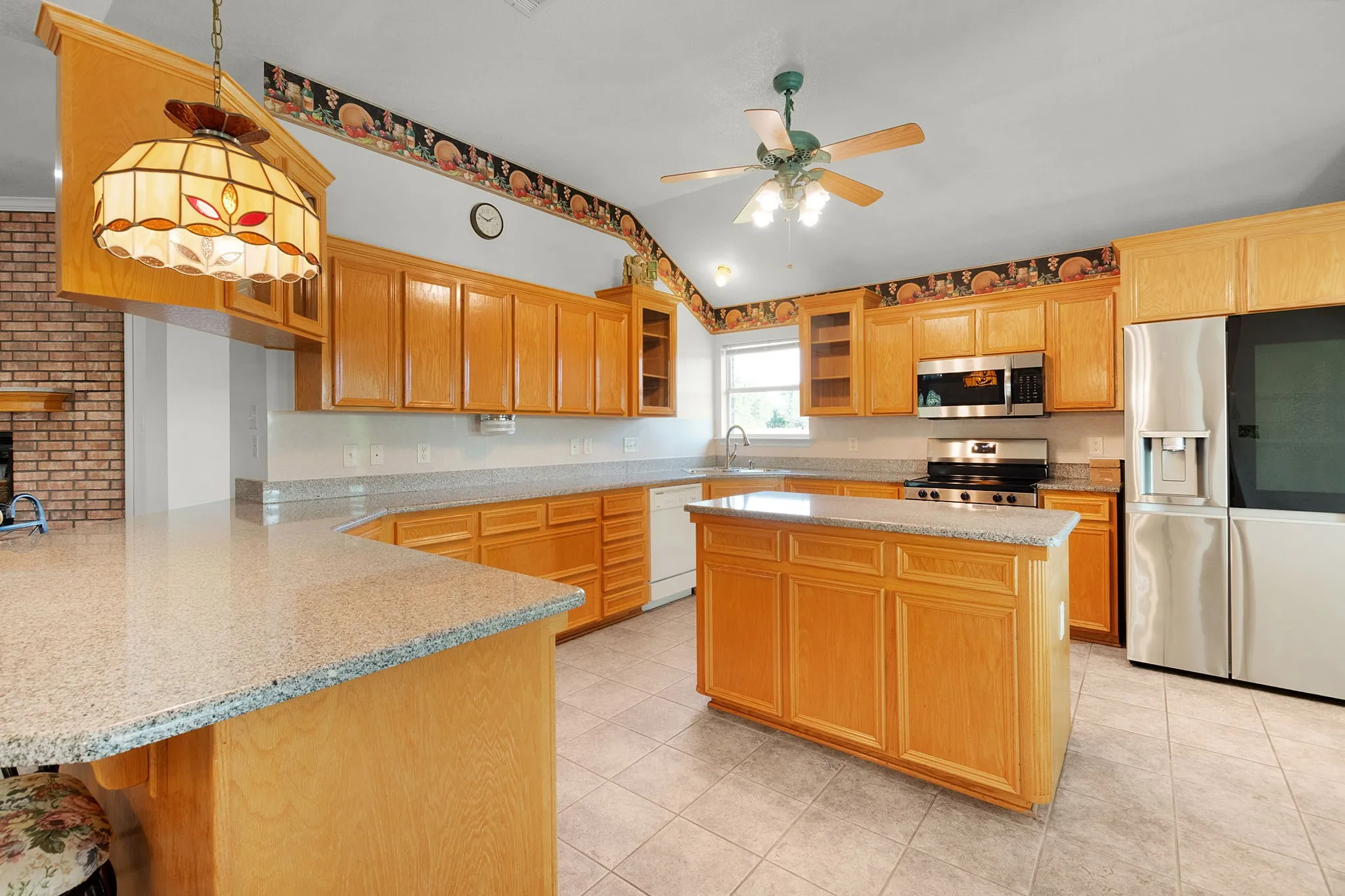 Kitchen featuring natural wood cabinetry and a central island with a solid surface countertop