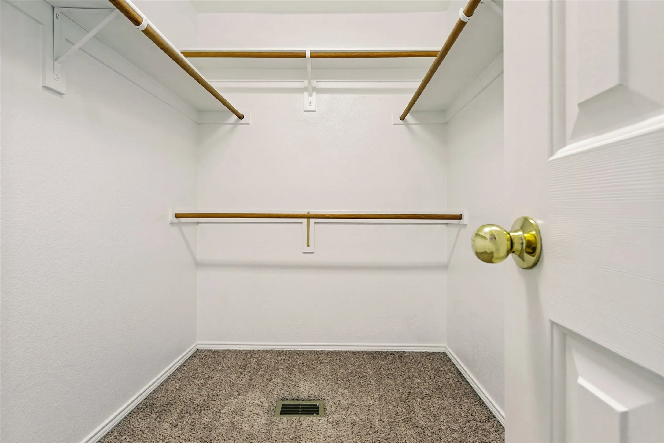 White interior walls with multiple wood-finish hanging rods