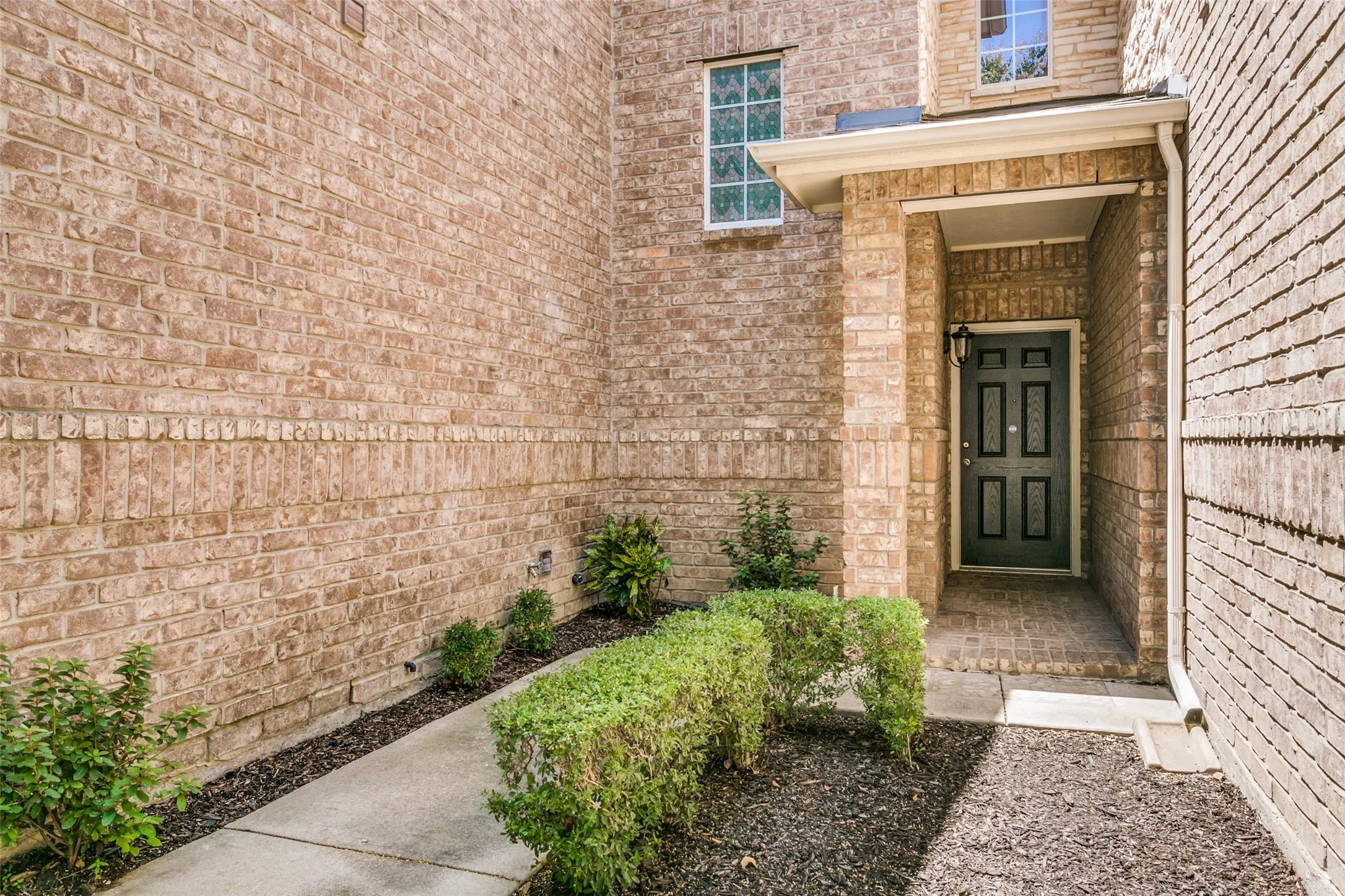 Brick exterior facade with a covered entry