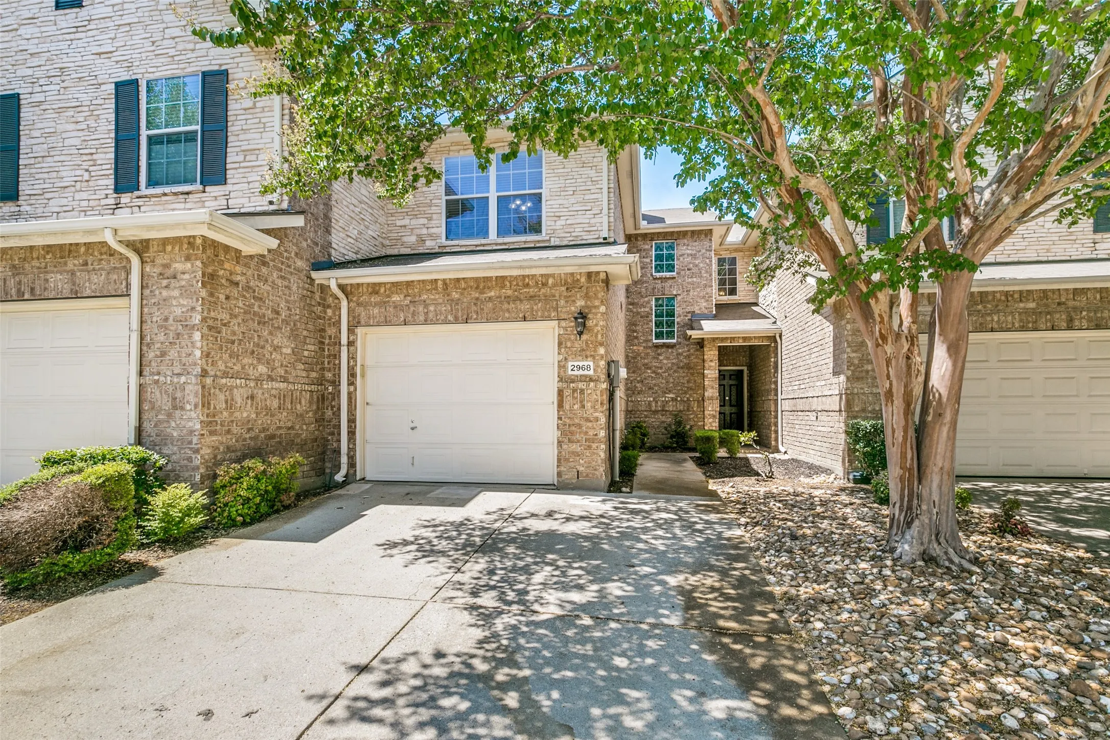 Brick and stone exterior with a covered entry and attached garage