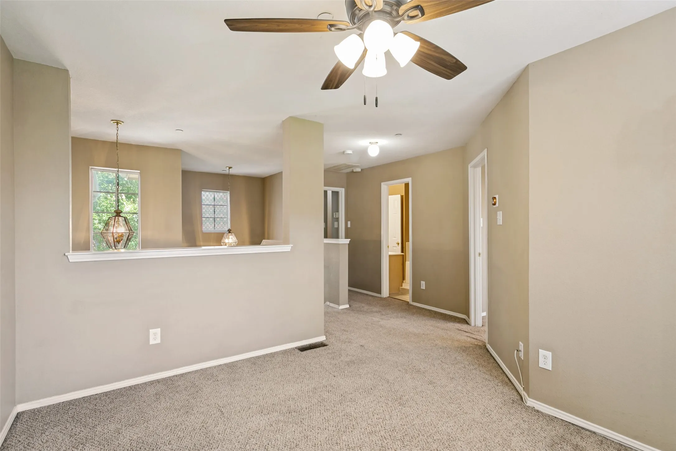 Carpeted interior with neutral wall finishes and a ceiling fan with integrated lighting