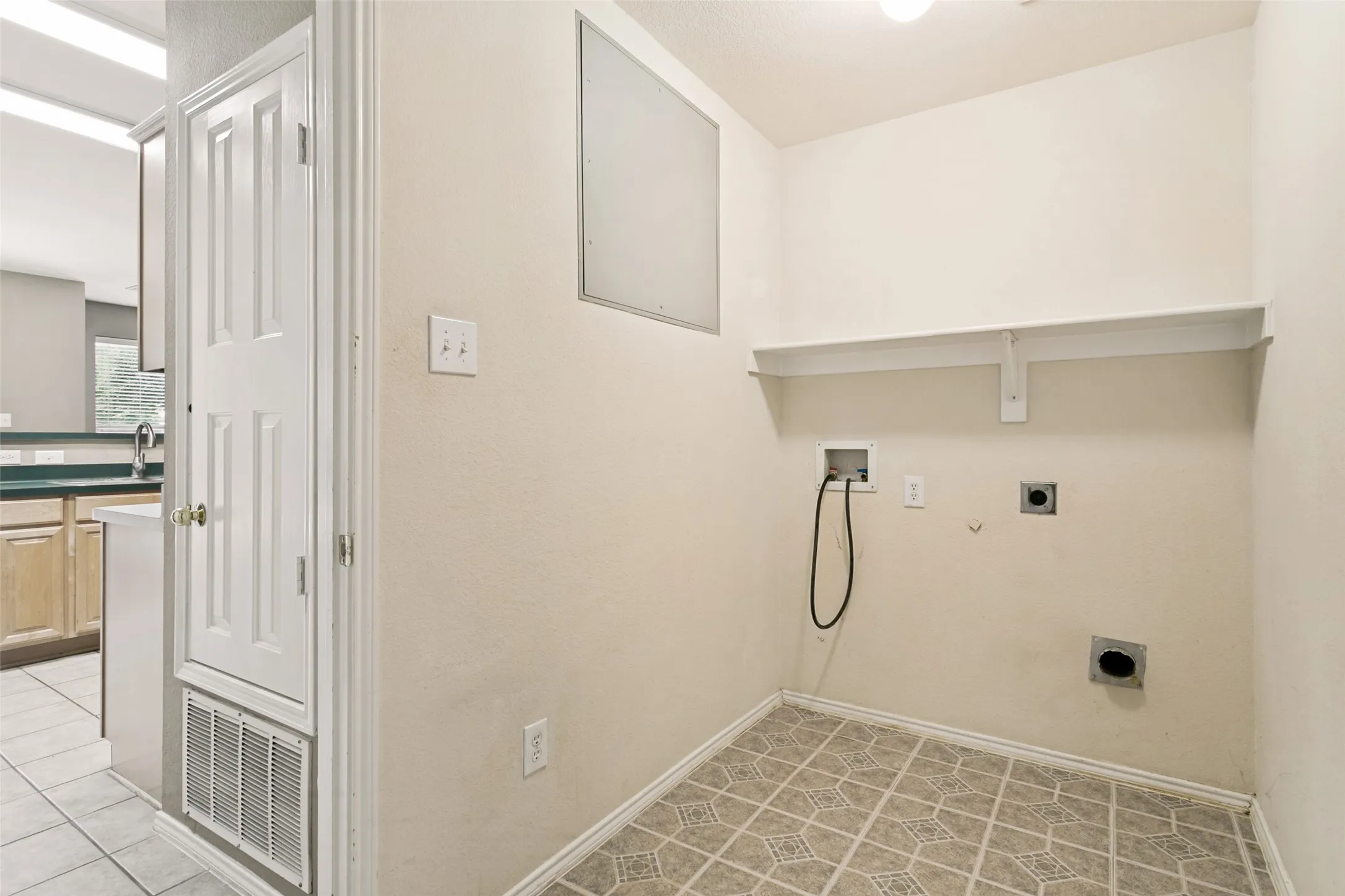 Utility room featuring a built-in shelf and appliance hookups.