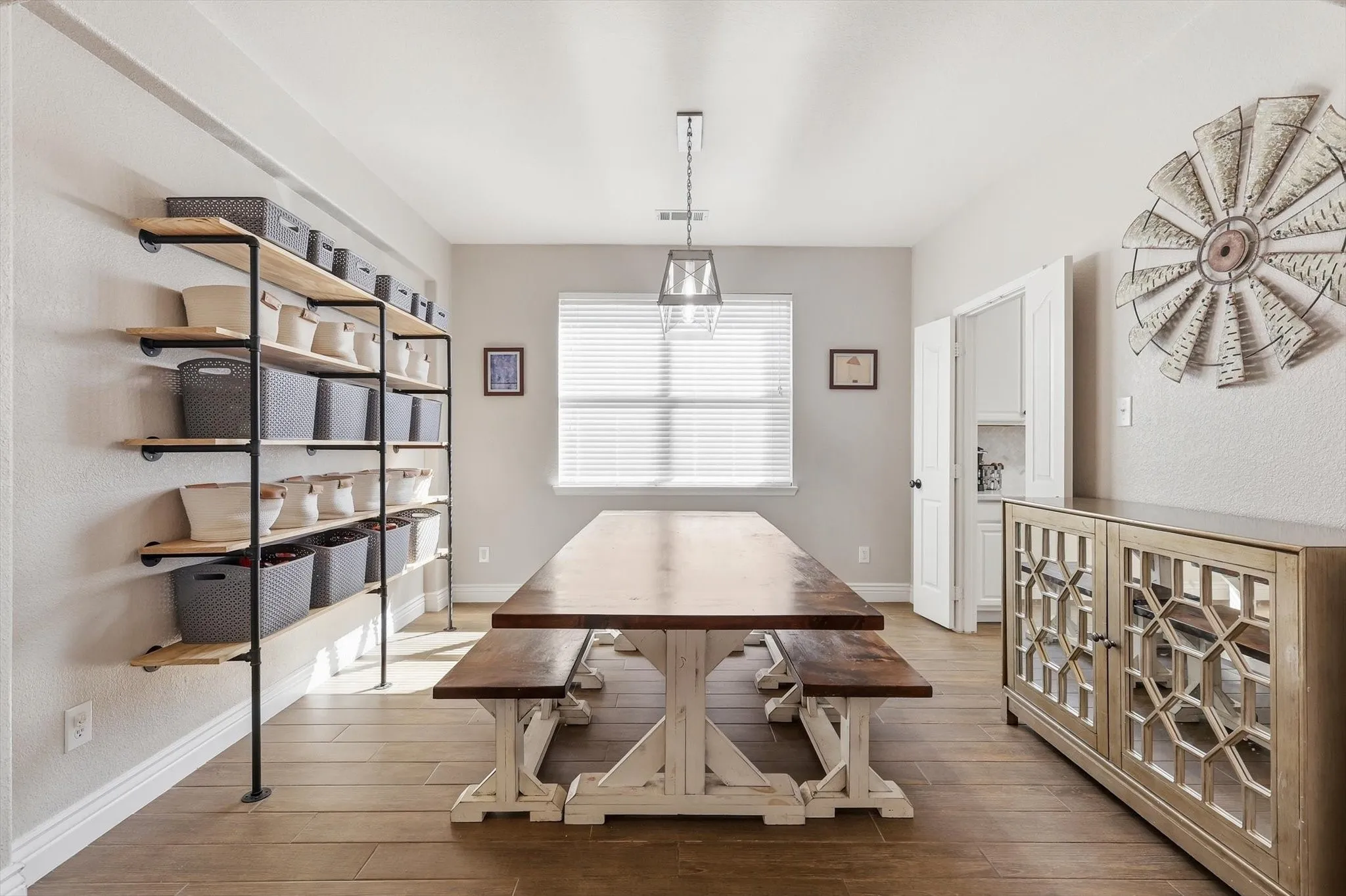 Spacious dining area featuring wood-finish flooring and a central window with blinds