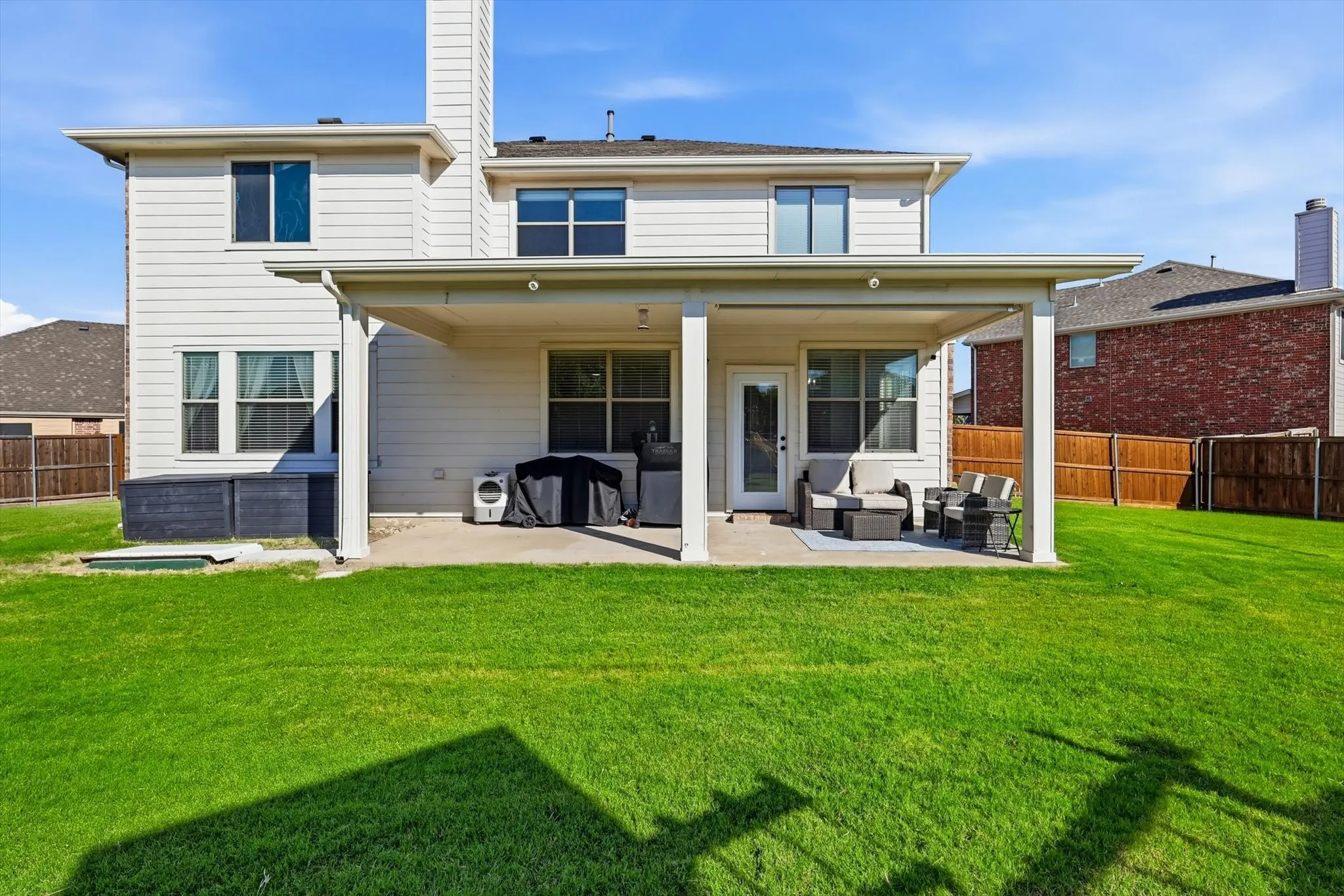 Spacious backyard featuring a manicured lawn, a full-coverage patio, and a privacy fence
