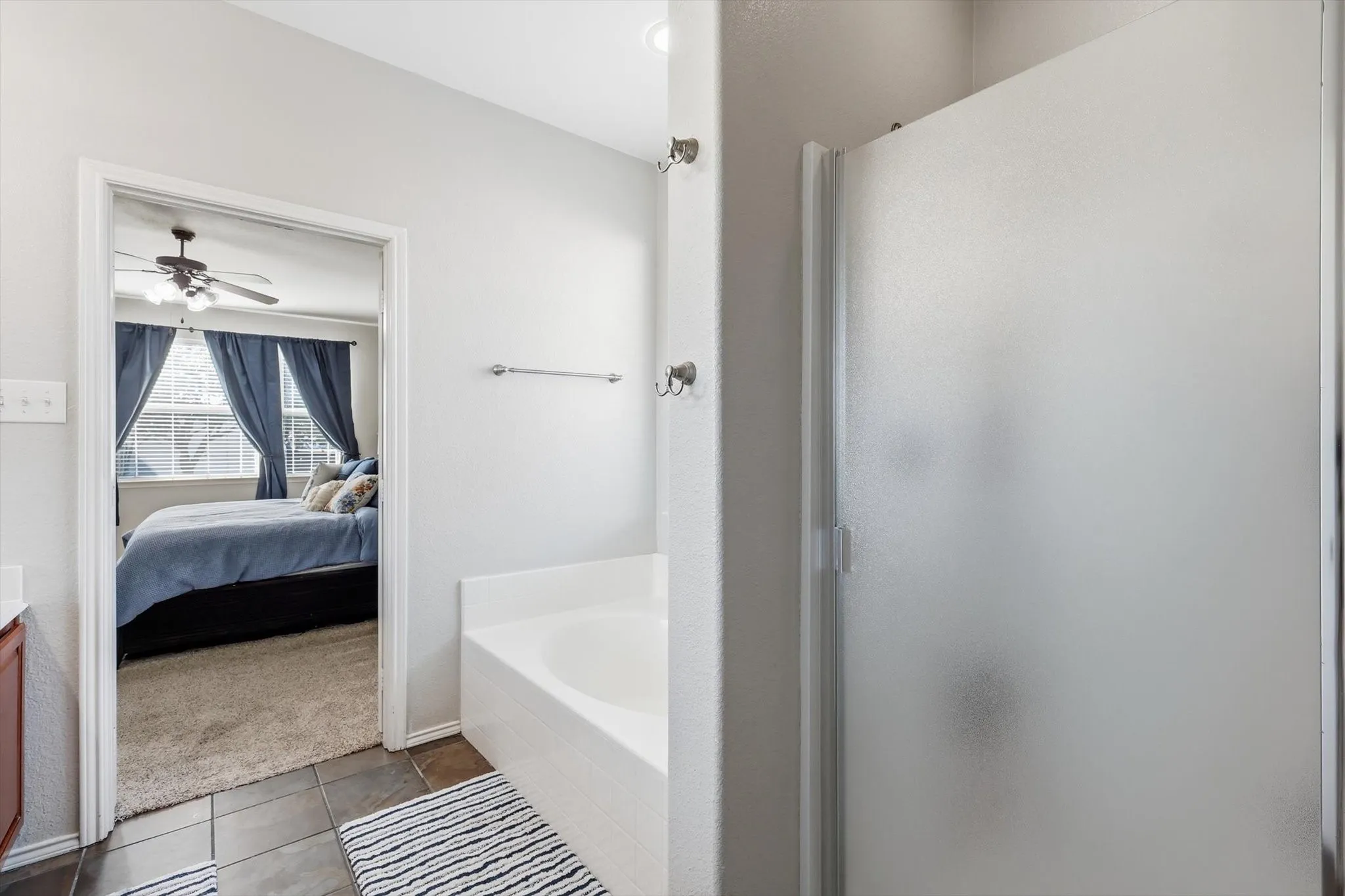 Bathroom with a built-in tub and a separate shower featuring a frosted glass enclosure