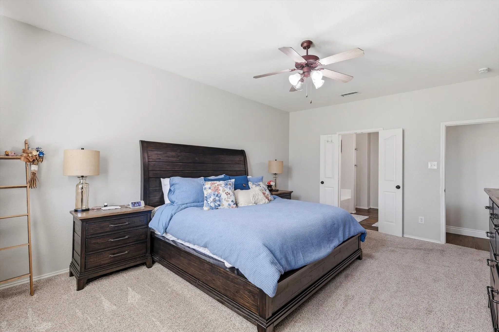 Primary- Carpeted room featuring light gray walls and a vaulted ceiling