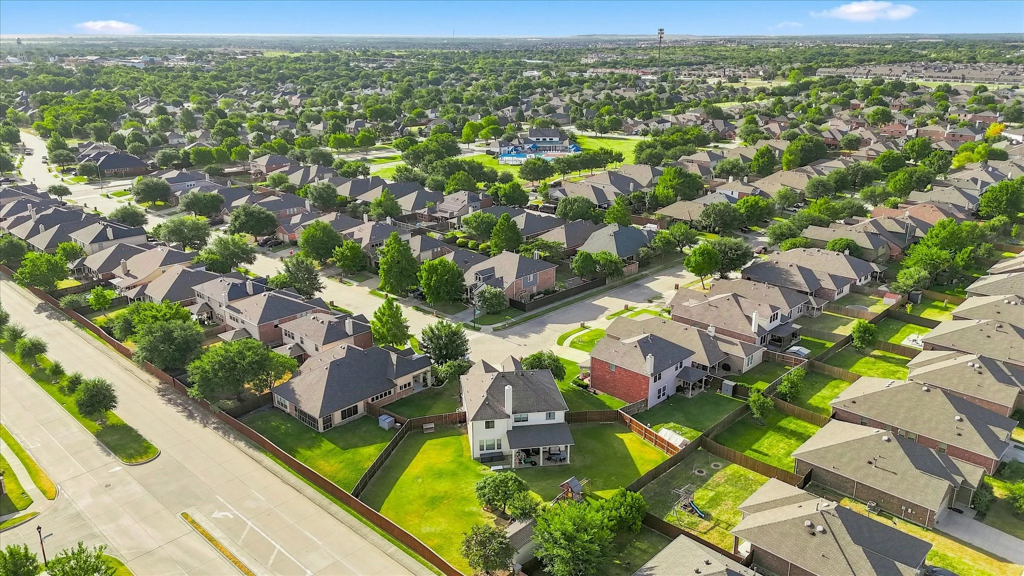 Expansive neighborhood featuring mature trees, residential properties, and a community pool